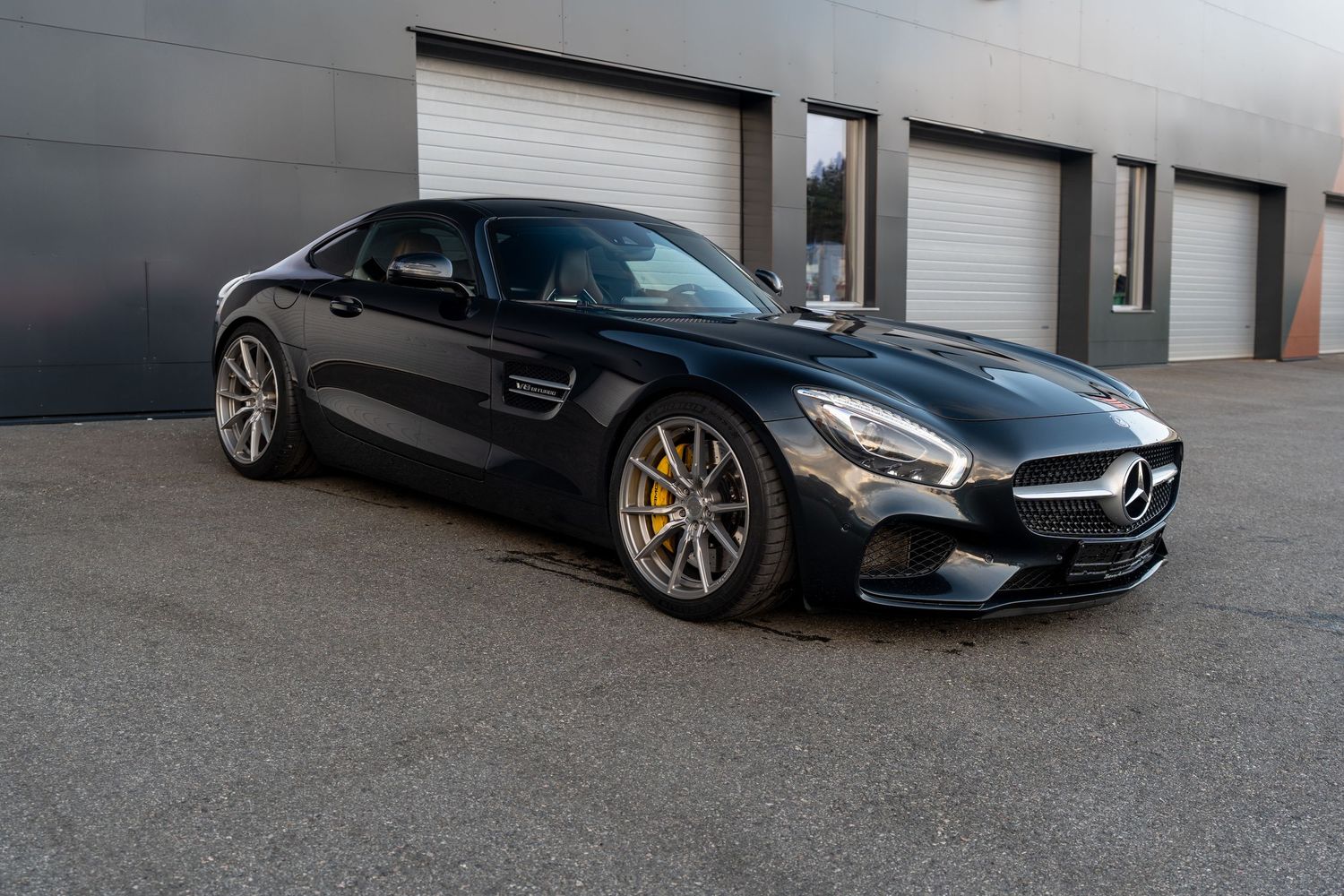 Side profile of a black Mercedes-AMG GT displaying its long hood and muscular proportions. bergen