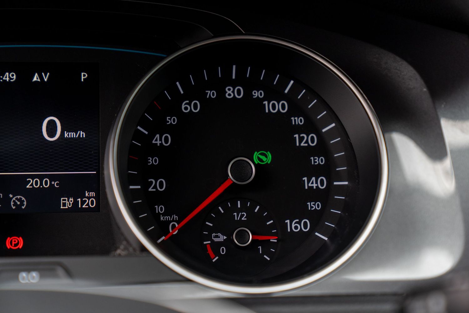 Close-up view of digital instrument panel displaying vehicle gauges and indicators in dark lighting.