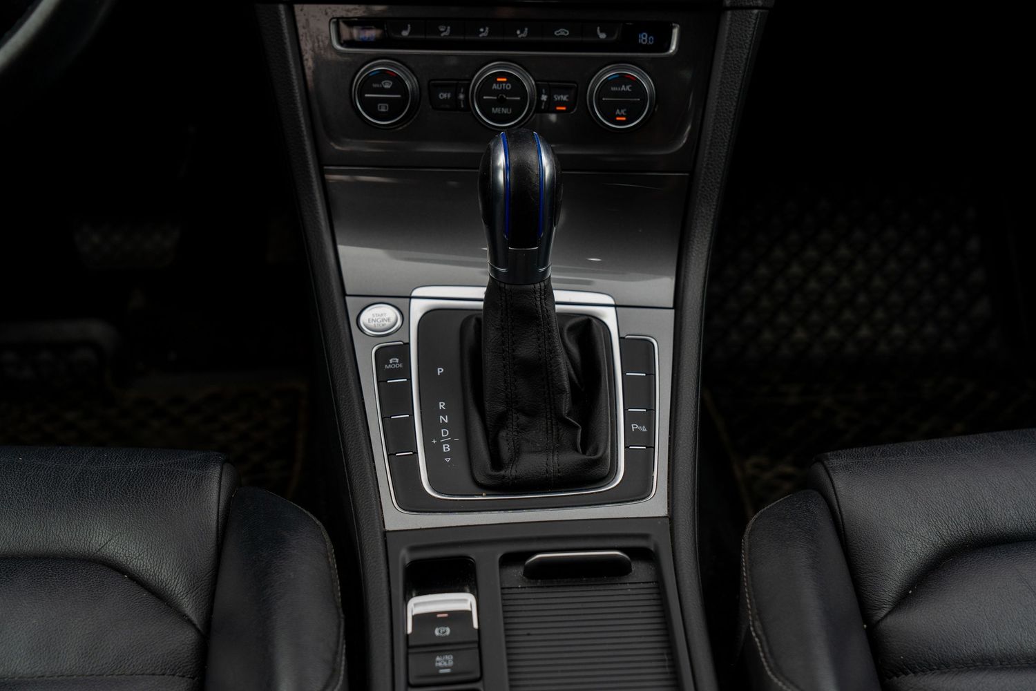 Interior center console of Volkswagen Golf showing gear shifter and controls.