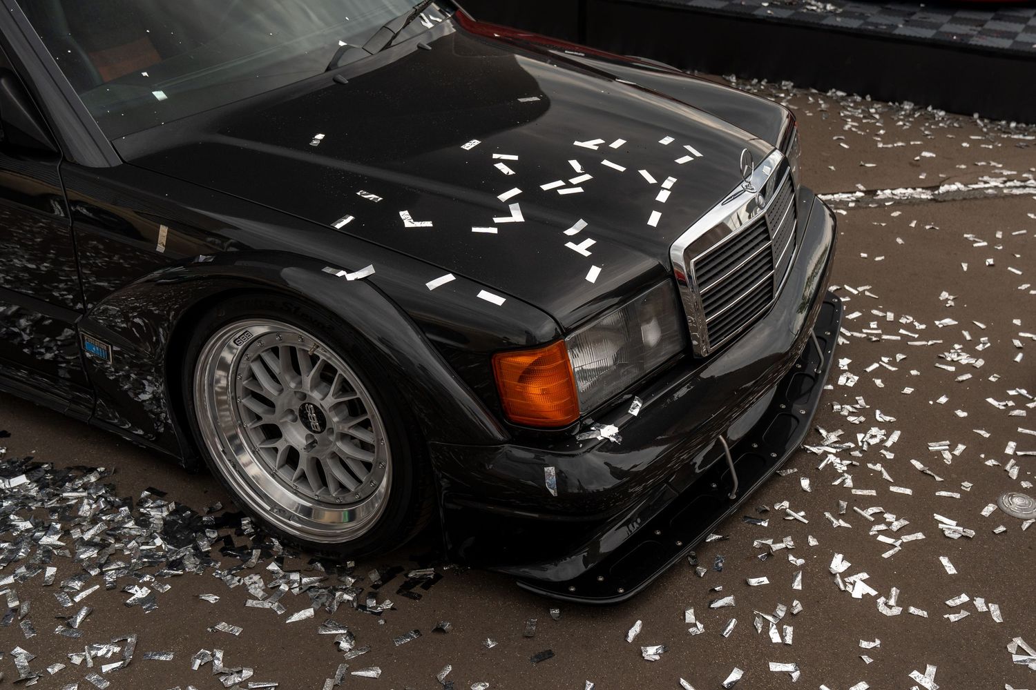 Modified black Mercedes-Benz with custom wheels and performance modifications covered in chalk markings.