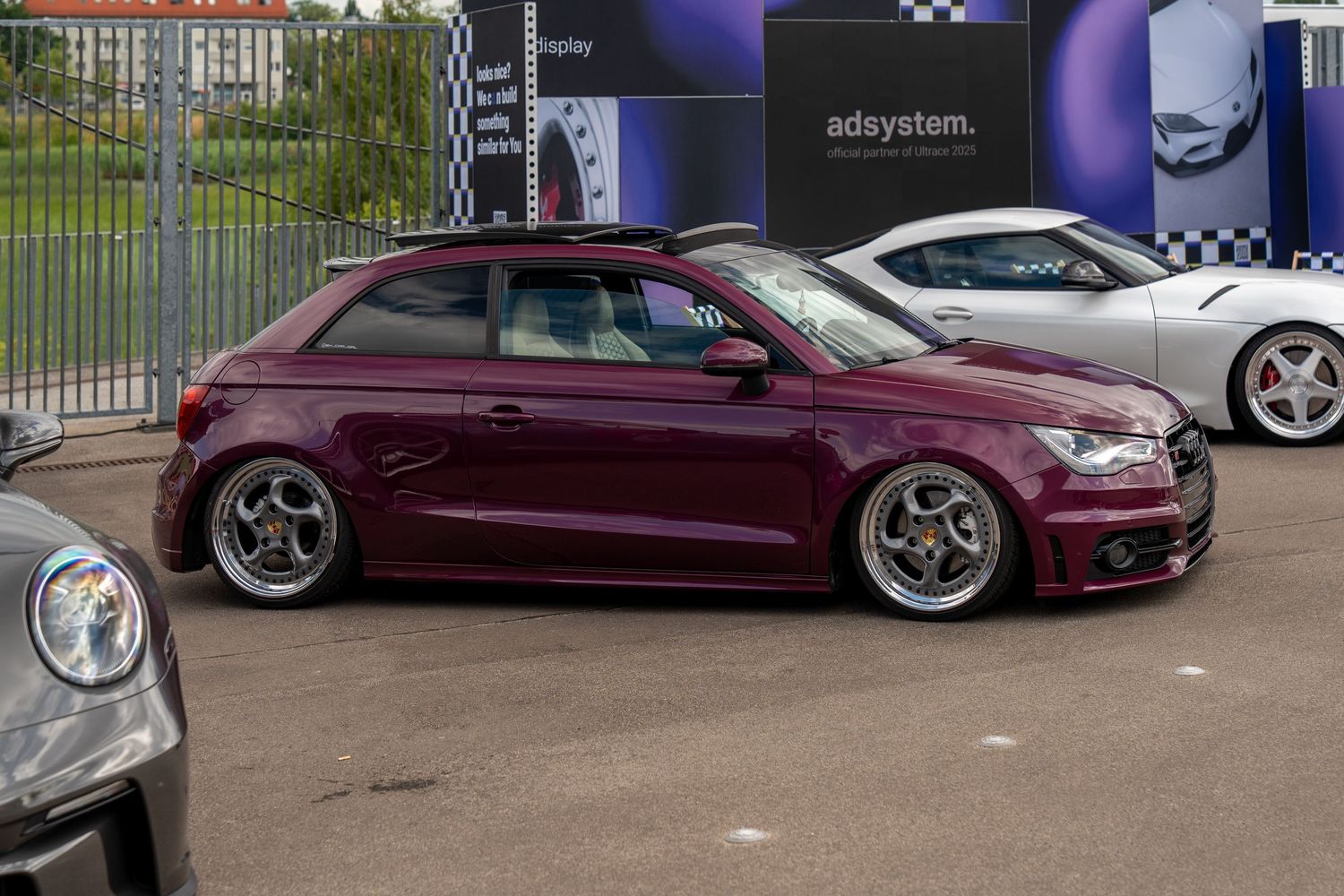 Modified burgundy Audi A1 hatchback with custom wheels and lowered suspension.