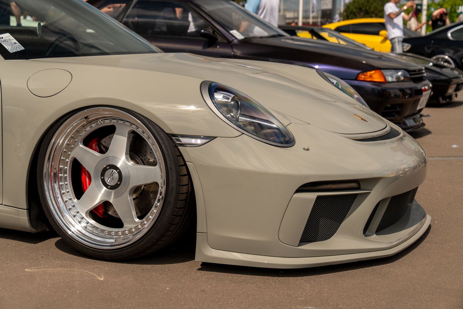 Close-up view of modified Porsche sports car with custom wheels.