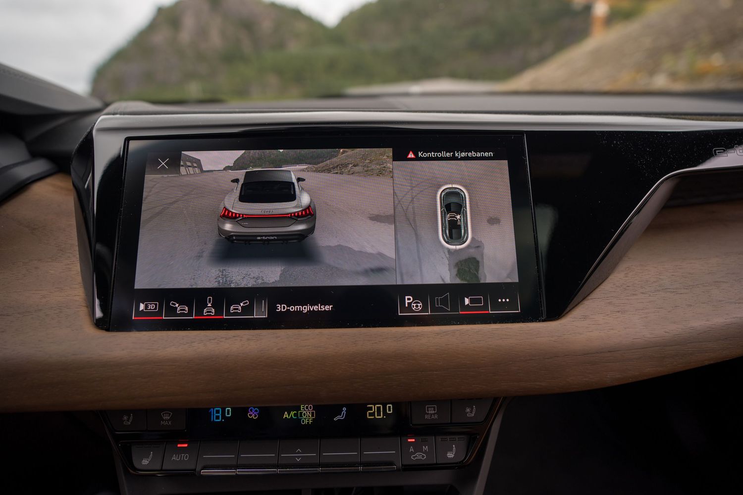 Modern car dashboard display showing rear view camera with parking assistance features.