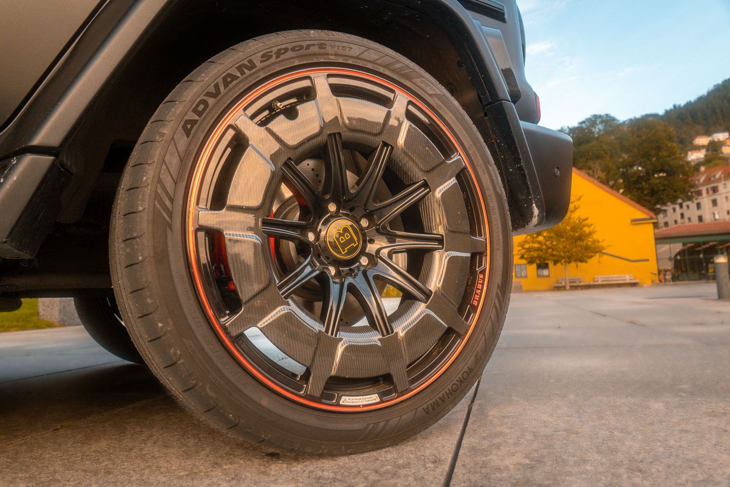 Close-up details of custom alloy wheels on a black Mercedes G-Wagon with red Brabus accents.