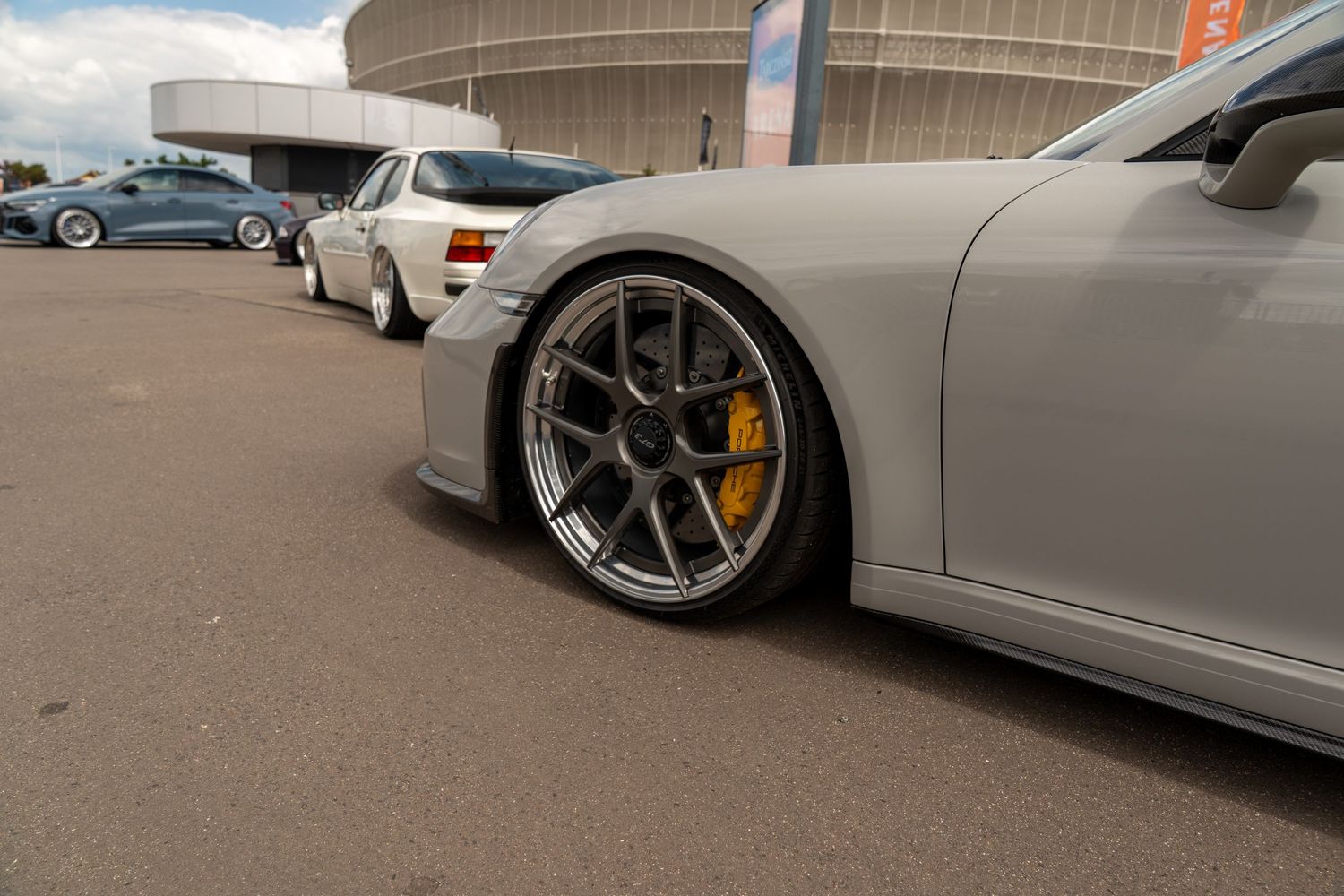 Custom white sports car wheel fitment showing off aftermarket rims and brake setup.