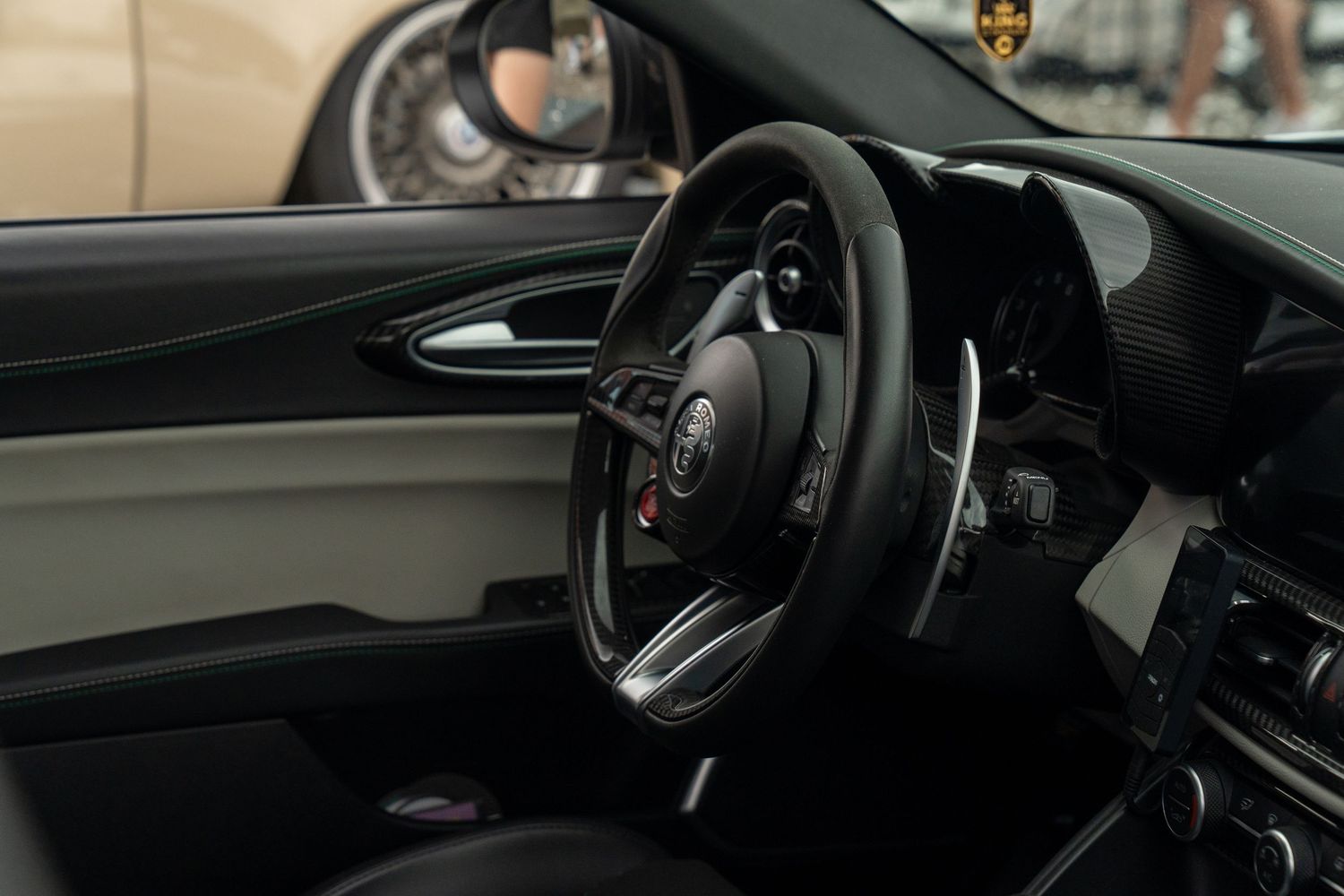 Interior view of a modern Porsche steering wheel and dashboard with black leather finishes.