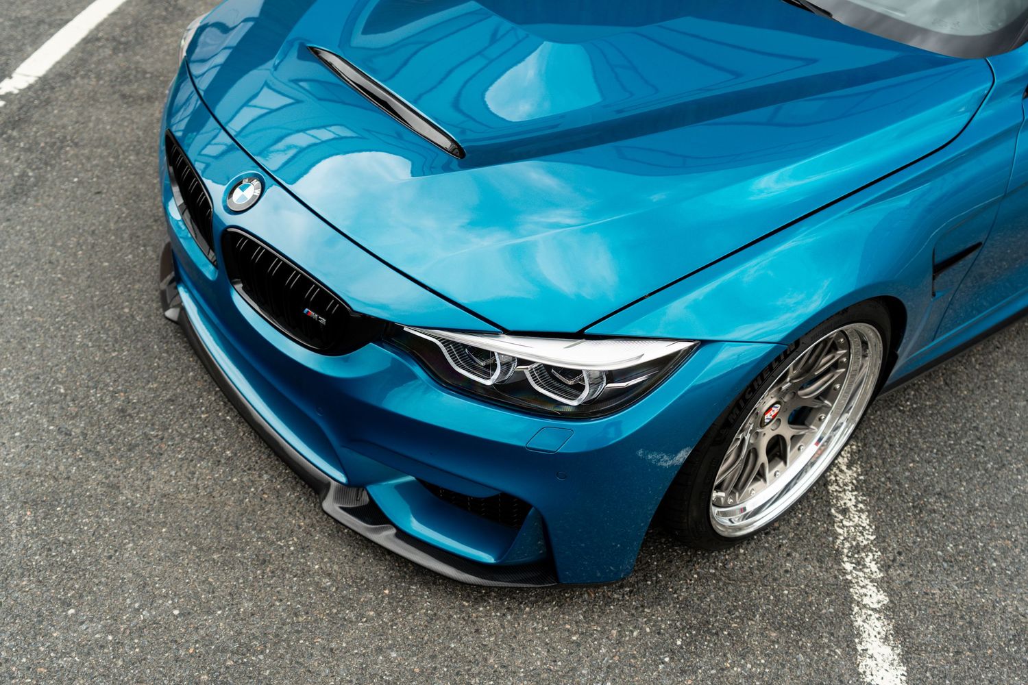 Close-up sequence showing detail shots of a bright blue BMW M2 sports car exterior from various angles.