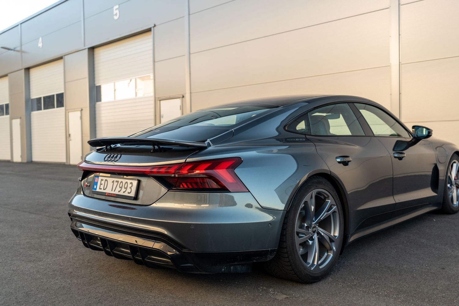 Low angle rear view of Audi RS e-tron GT highlighting aerodynamic diffuser and wide stance.