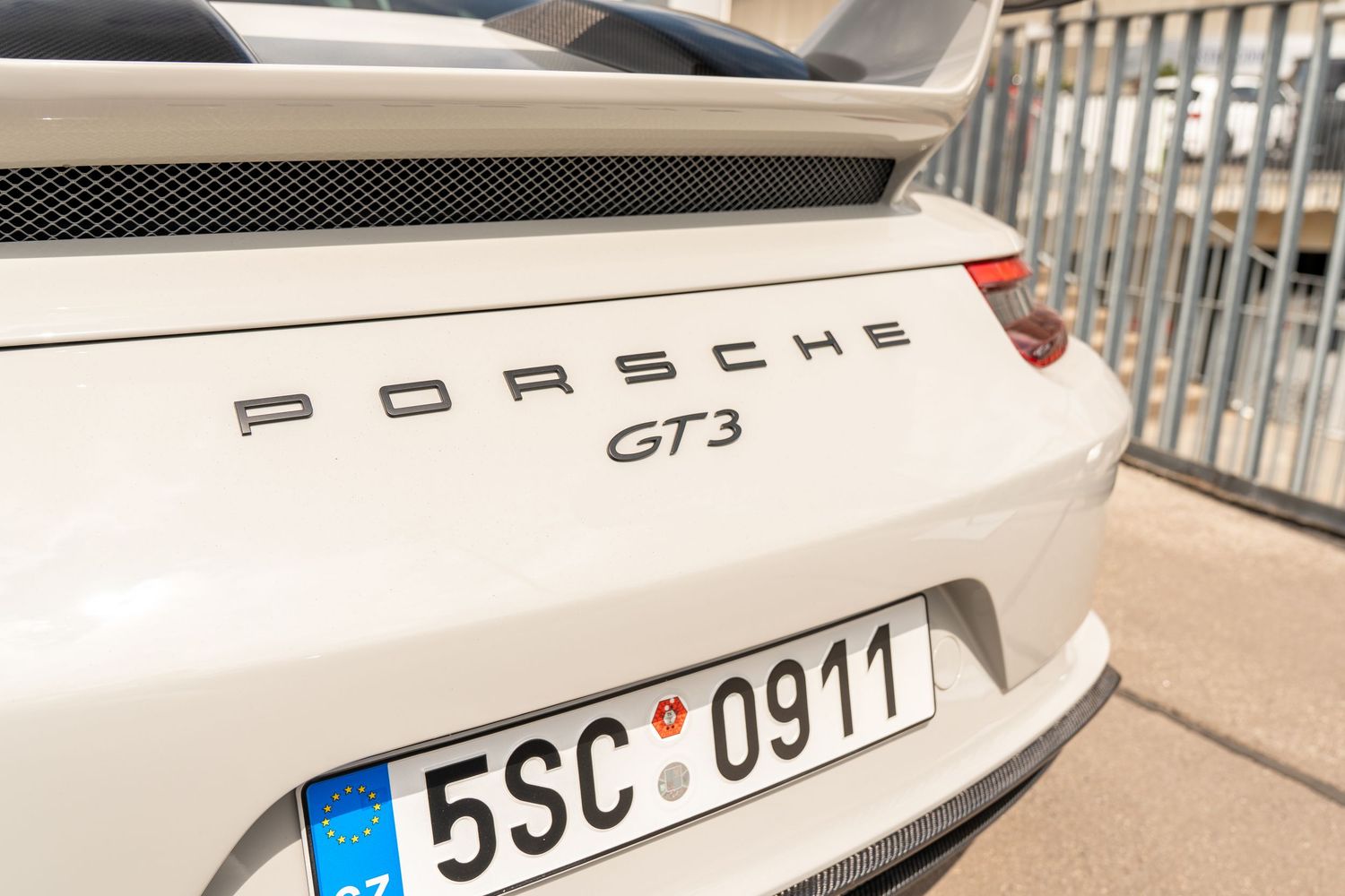 Close-up detail of white Porsche GT3 rear badge and license plate.