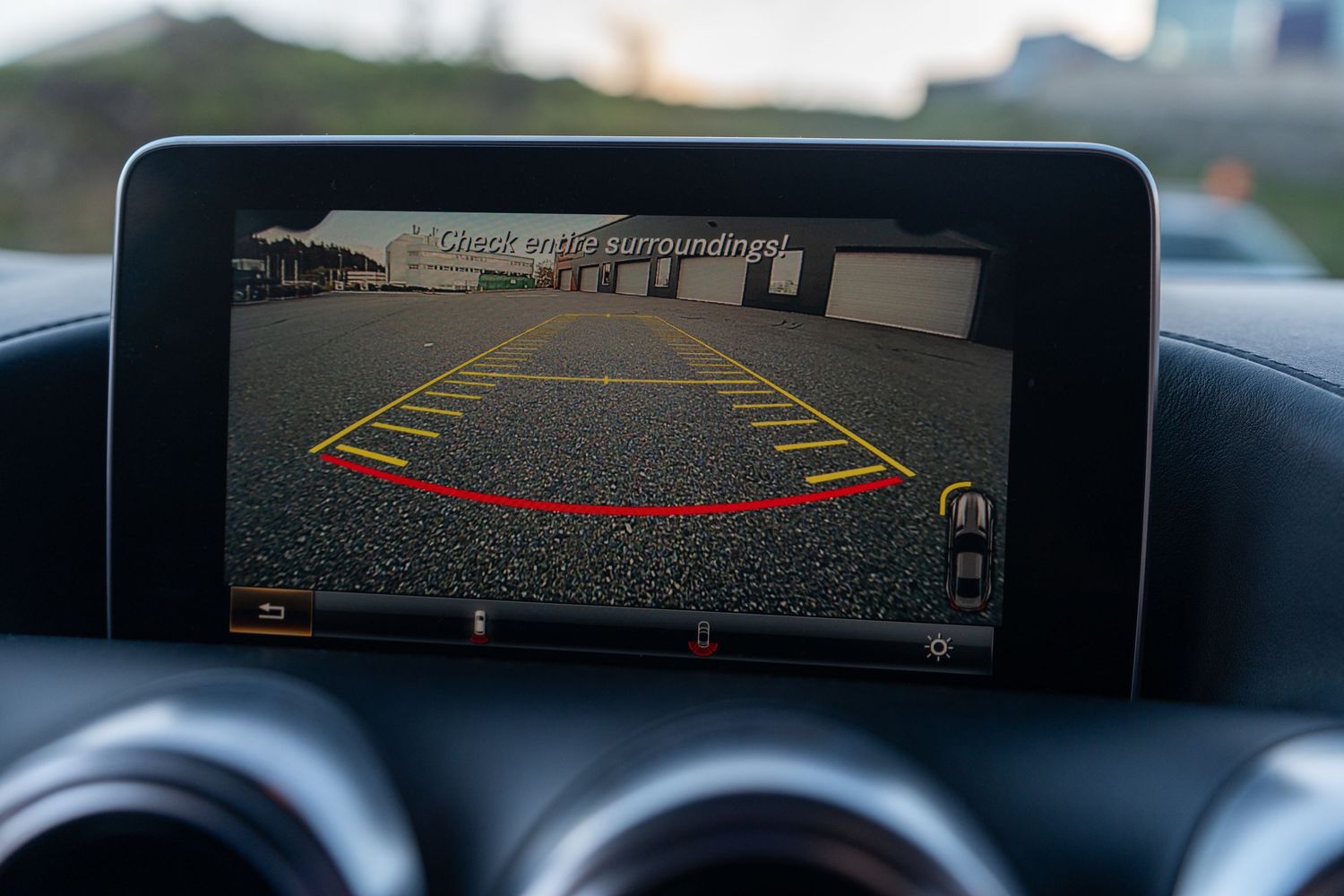 Backup camera display showing parking guide lines in vehicle infotainment screen.