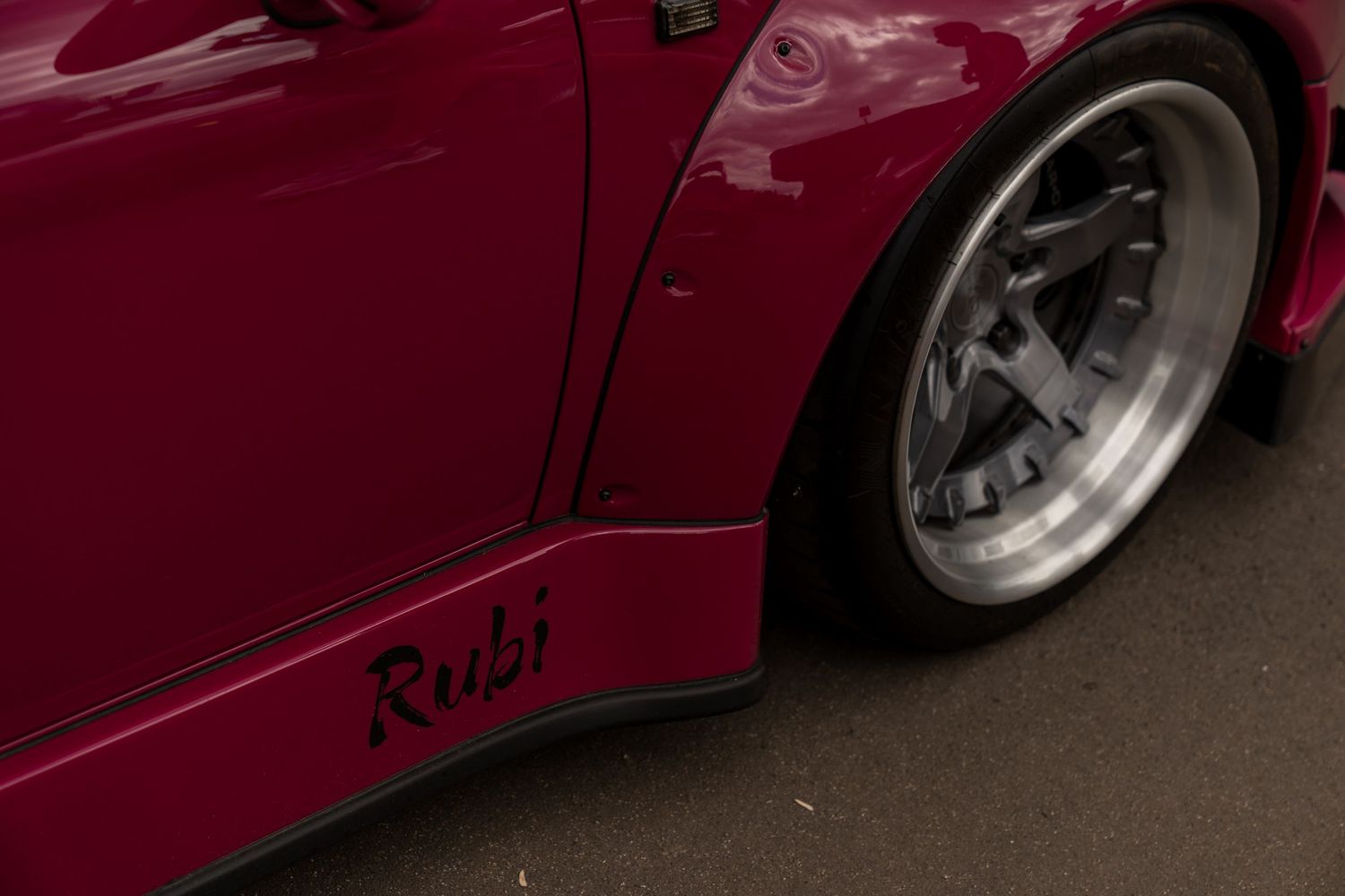 Deep red custom modified sports car showing side profile details.