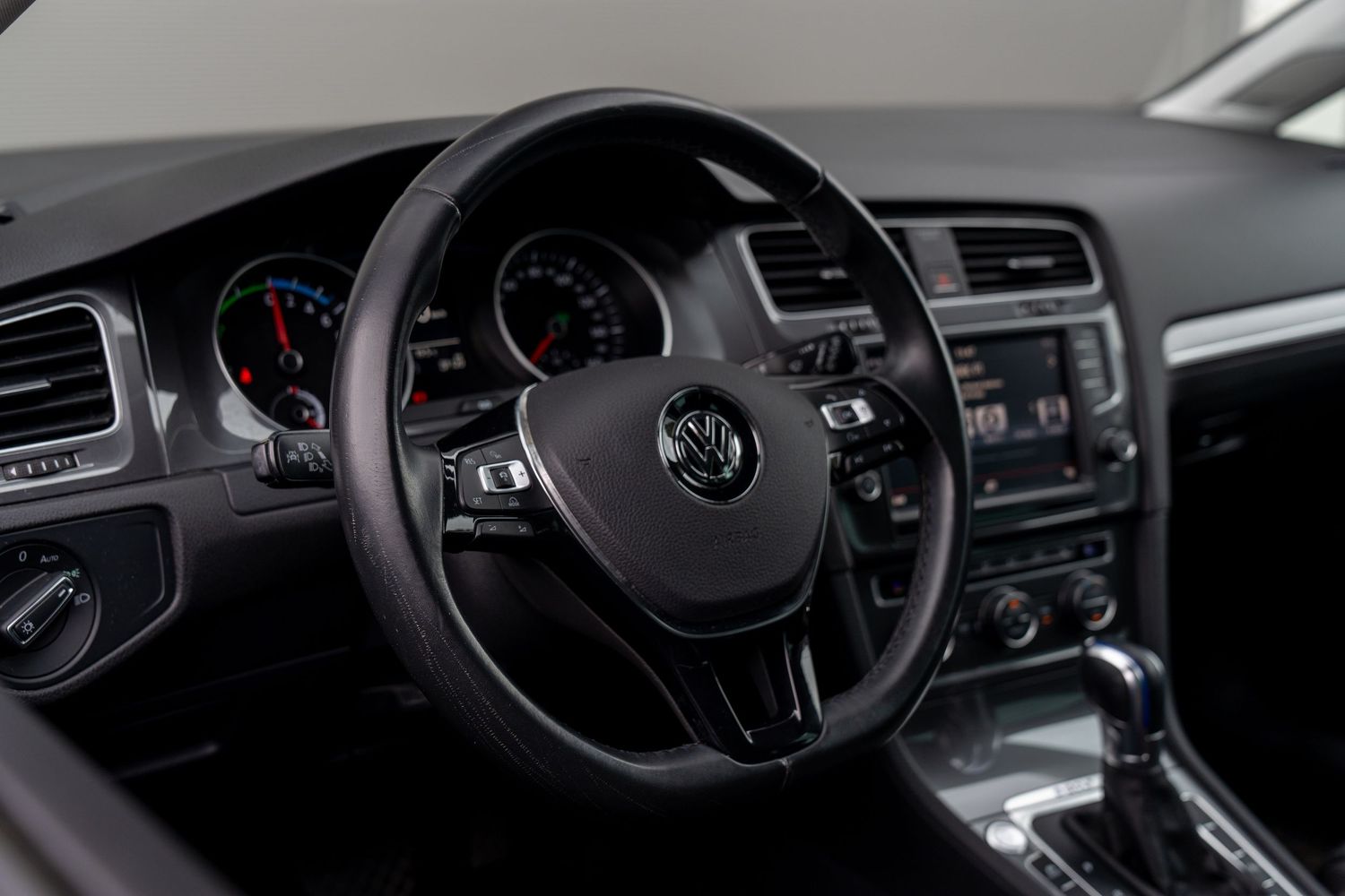 Interior view of a Volkswagen car dashboard showing modern displays and controls in black and silver trim.