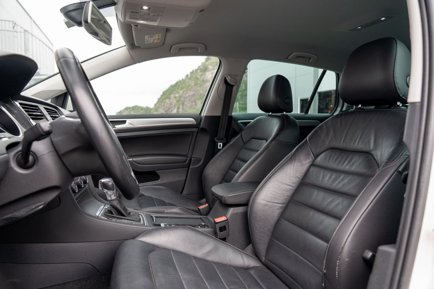 Interior dashboard and center console view of a modern Volkswagen Golf showing leather seats and controls.