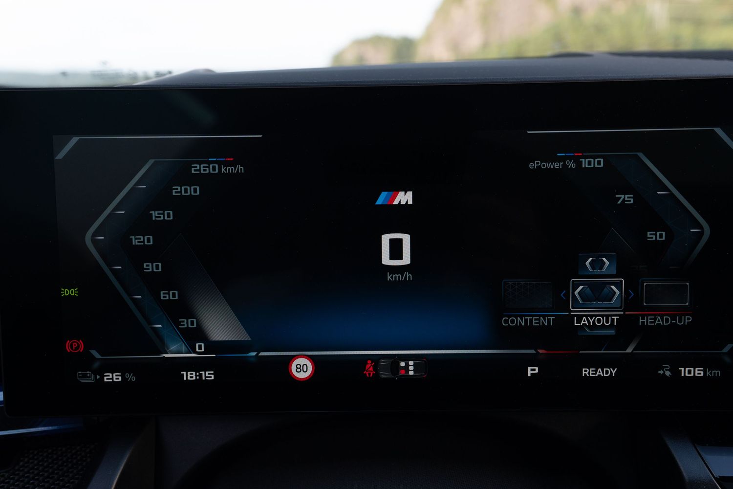 BMW's digital instrument cluster displaying speed and navigation information in blue illumination.