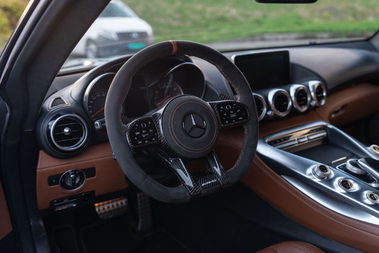 Mercedes-AMG GT interior featuring leather steering wheel and circular air vents.
