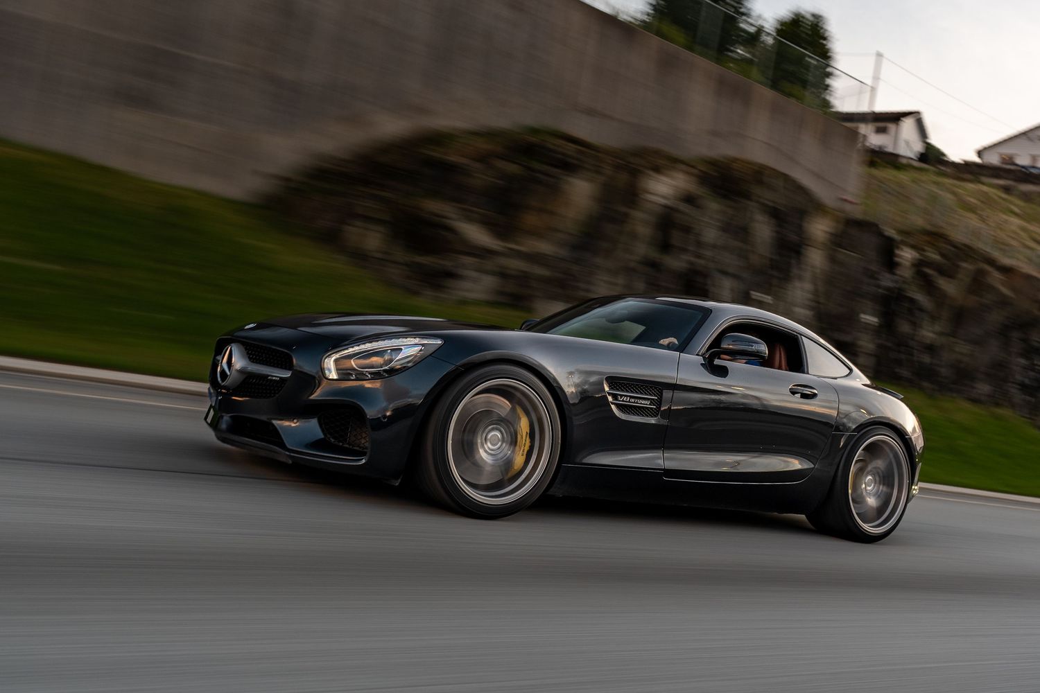Black Mercedes-AMG GT S photographed in motion on mountain road.