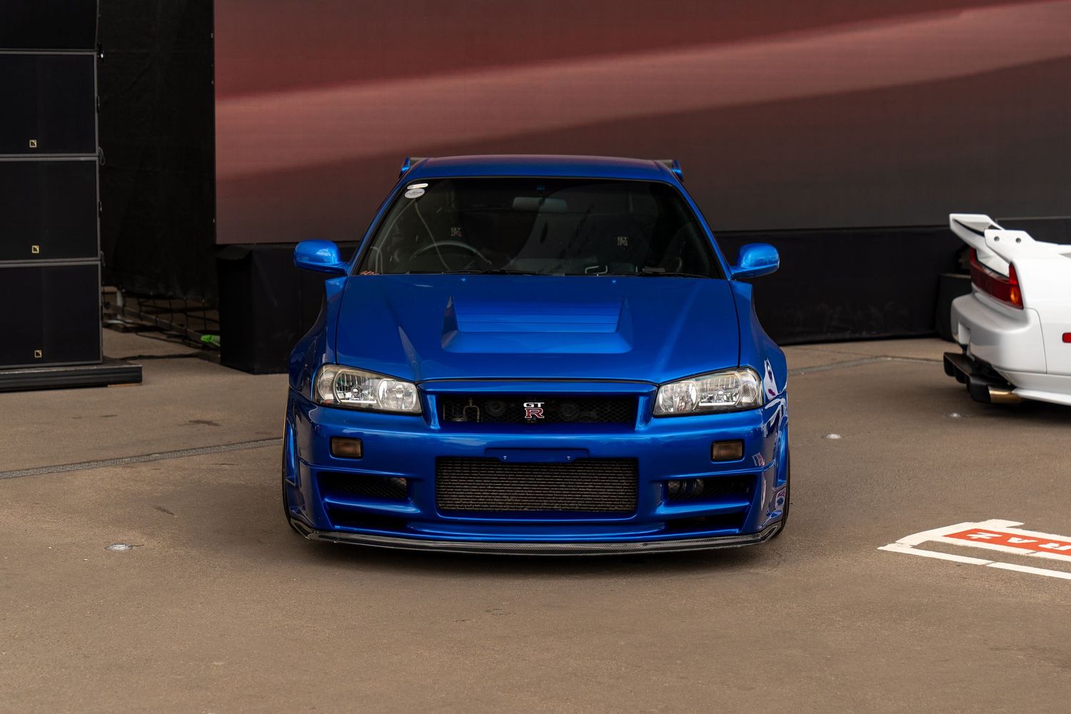 Lowered blue Honda Civic with custom body modifications displayed at automotive event.
