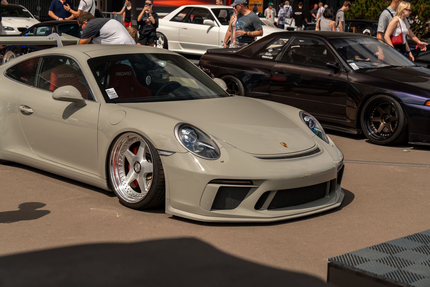 A silver Porsche 911 GT3 with aftermarket wheels parked at an outdoor car show.