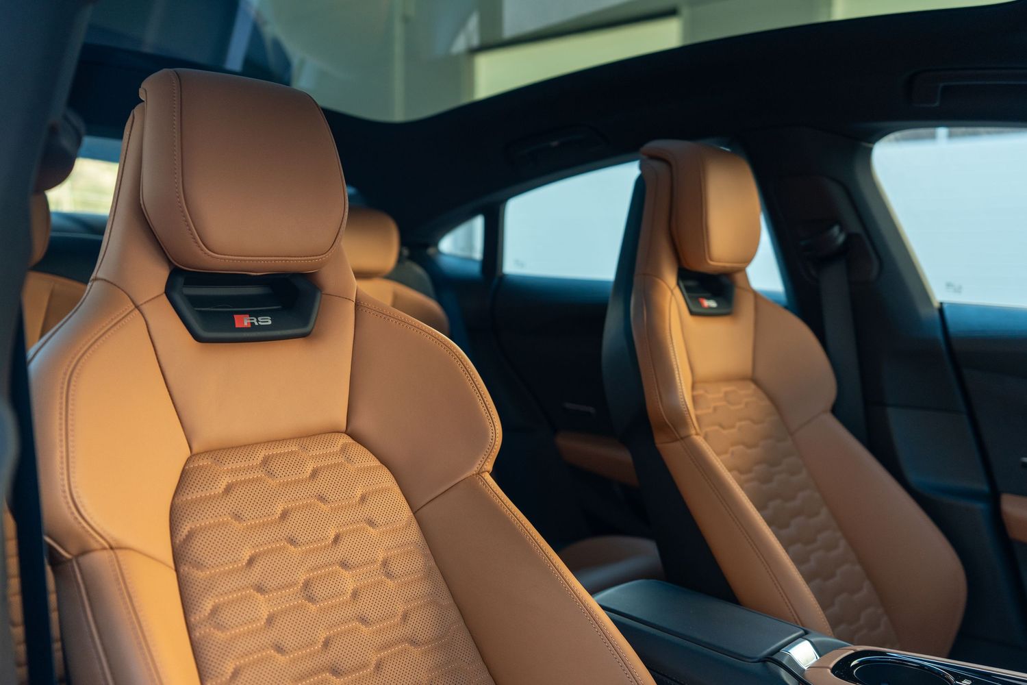 Sport seats with quilted tan leather upholstery and integrated headrests.
