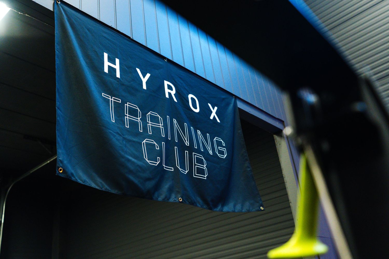 A dark interior space with illuminated blue signage mounted on a wall showing partial text and letters.