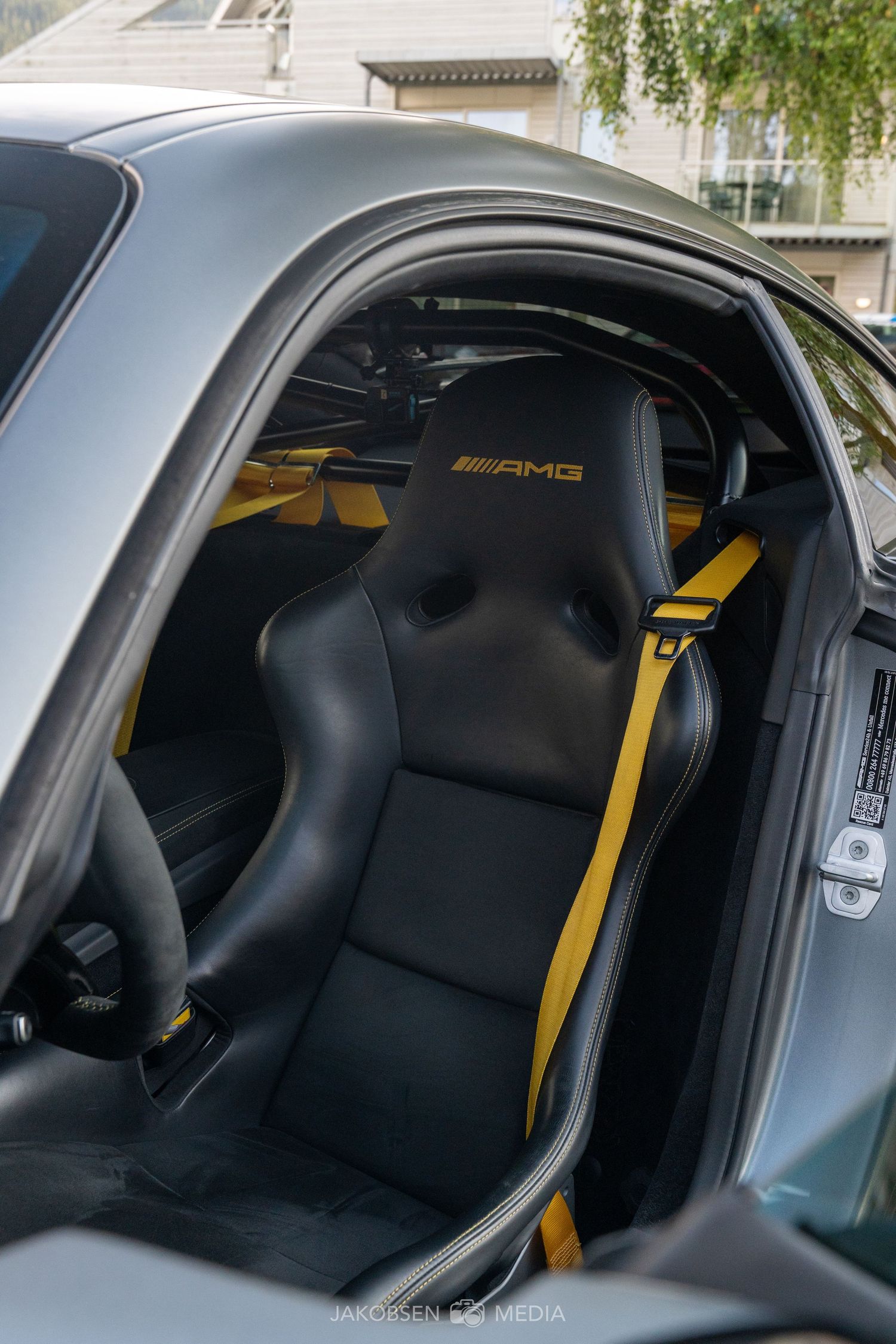 Interior view of AMG Mercedes sports car showing black and yellow racing seats.