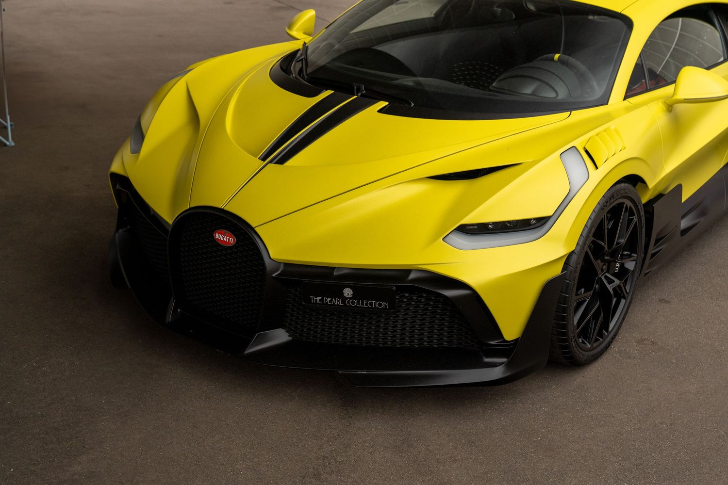 Bright yellow Bugatti Divo supercar with striking black accents and aggressive front aerodynamics.