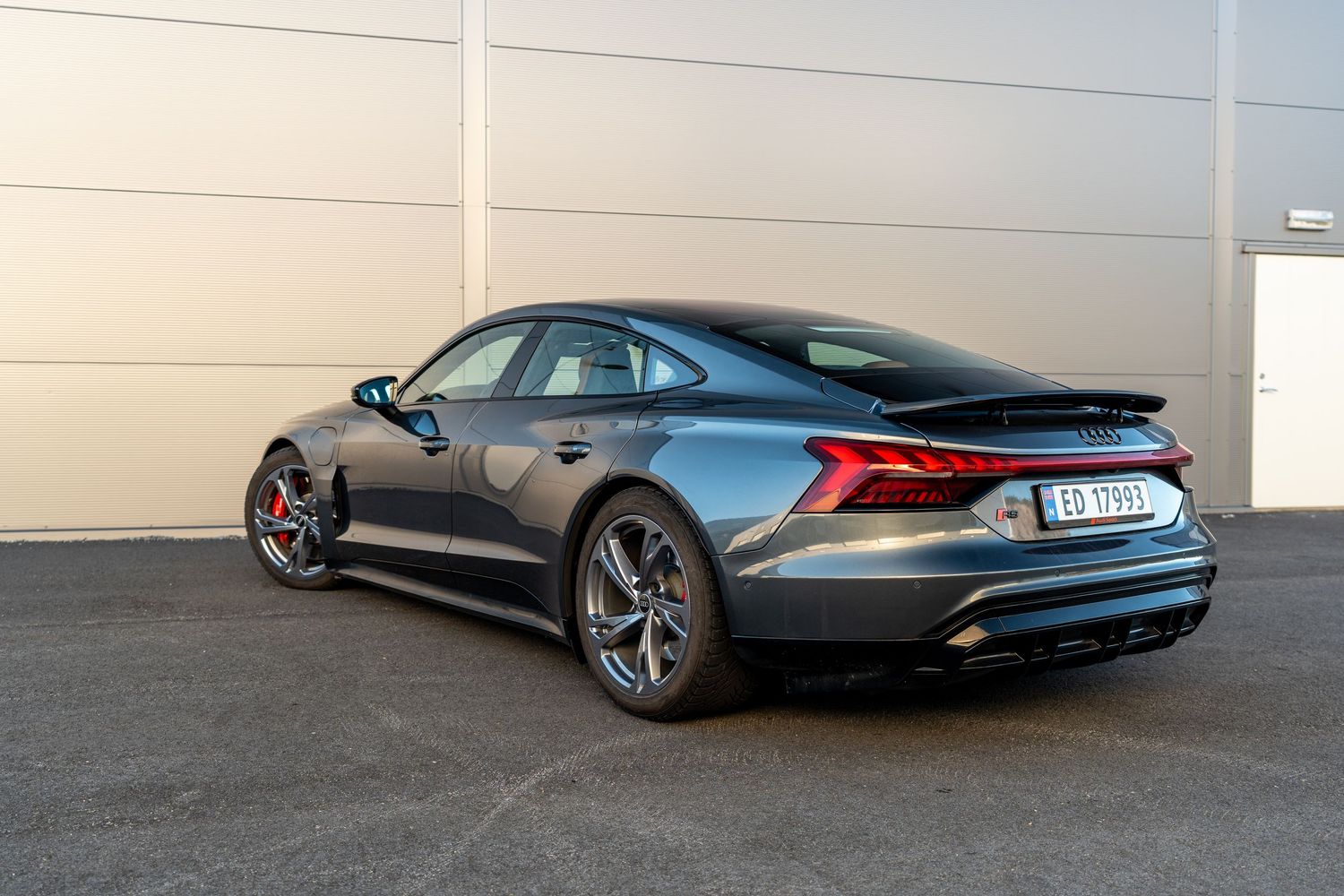 Rear three-quarter view of grey Audi RS e-tron GT showcasing sporty fastback design.
