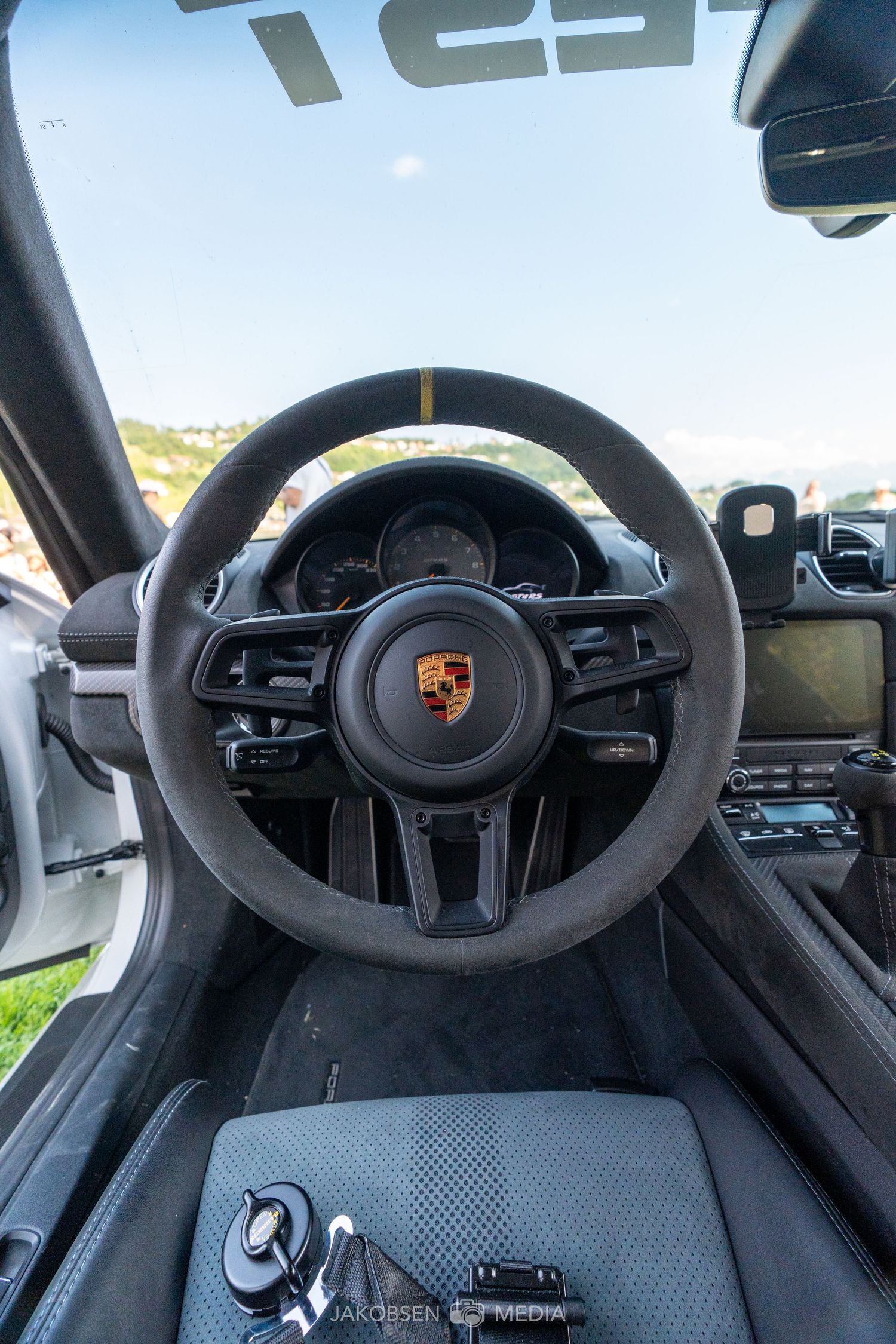 Modern Porsche interior showing steering wheel and digital dashboard displays.