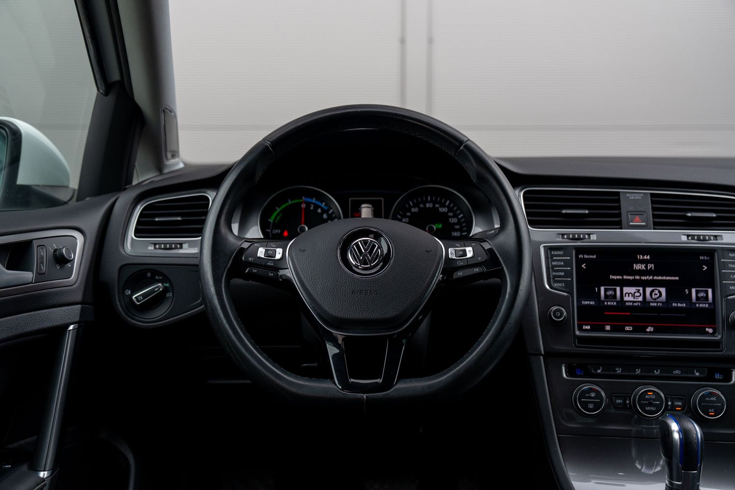 Modern car dashboard with digital displays showing navigation, climate controls, and vehicle information in sleek black finish.