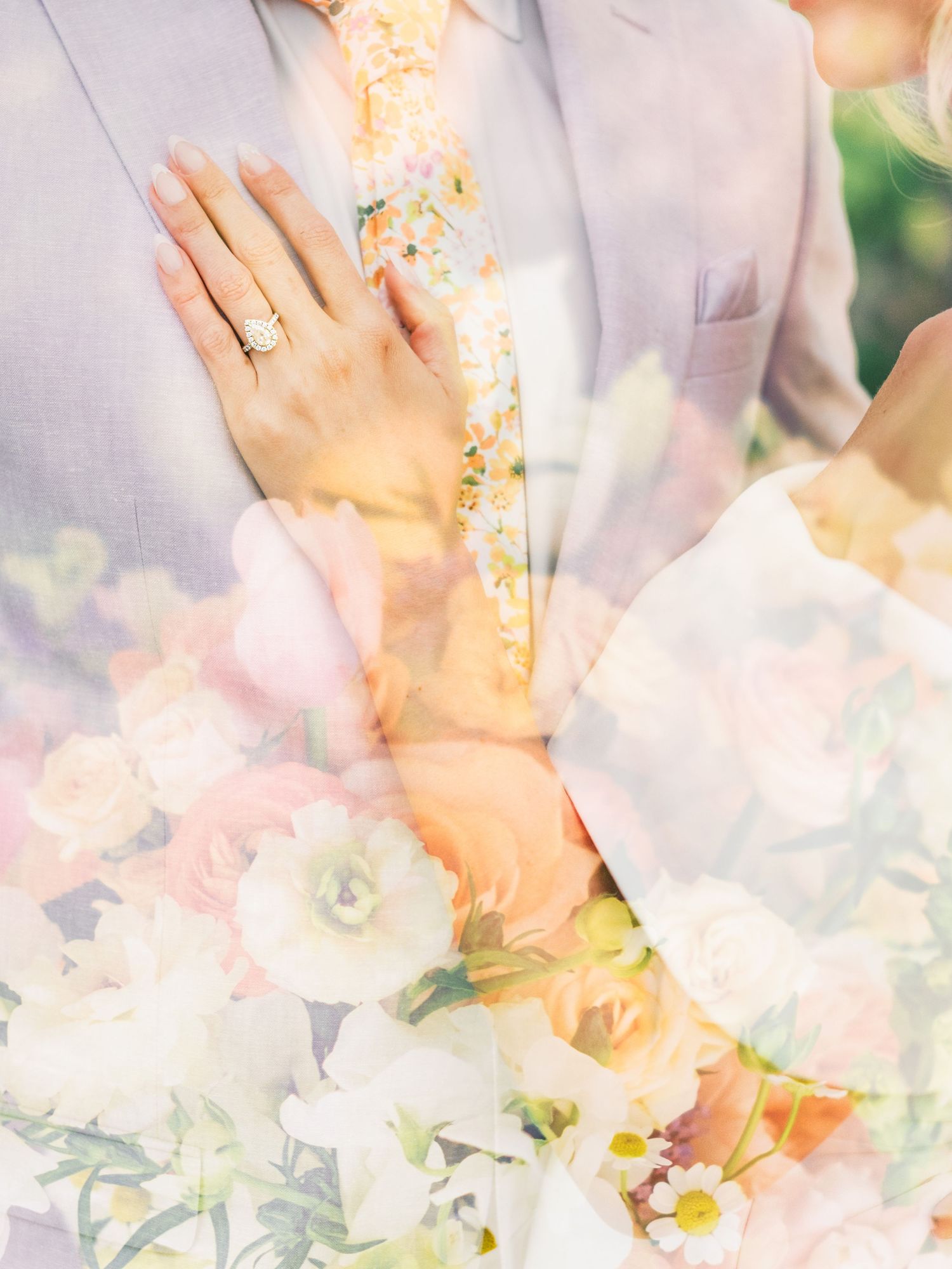 Double exposed wedding photo showing hands with rings overlaid with delicate white and pink floral blooms.