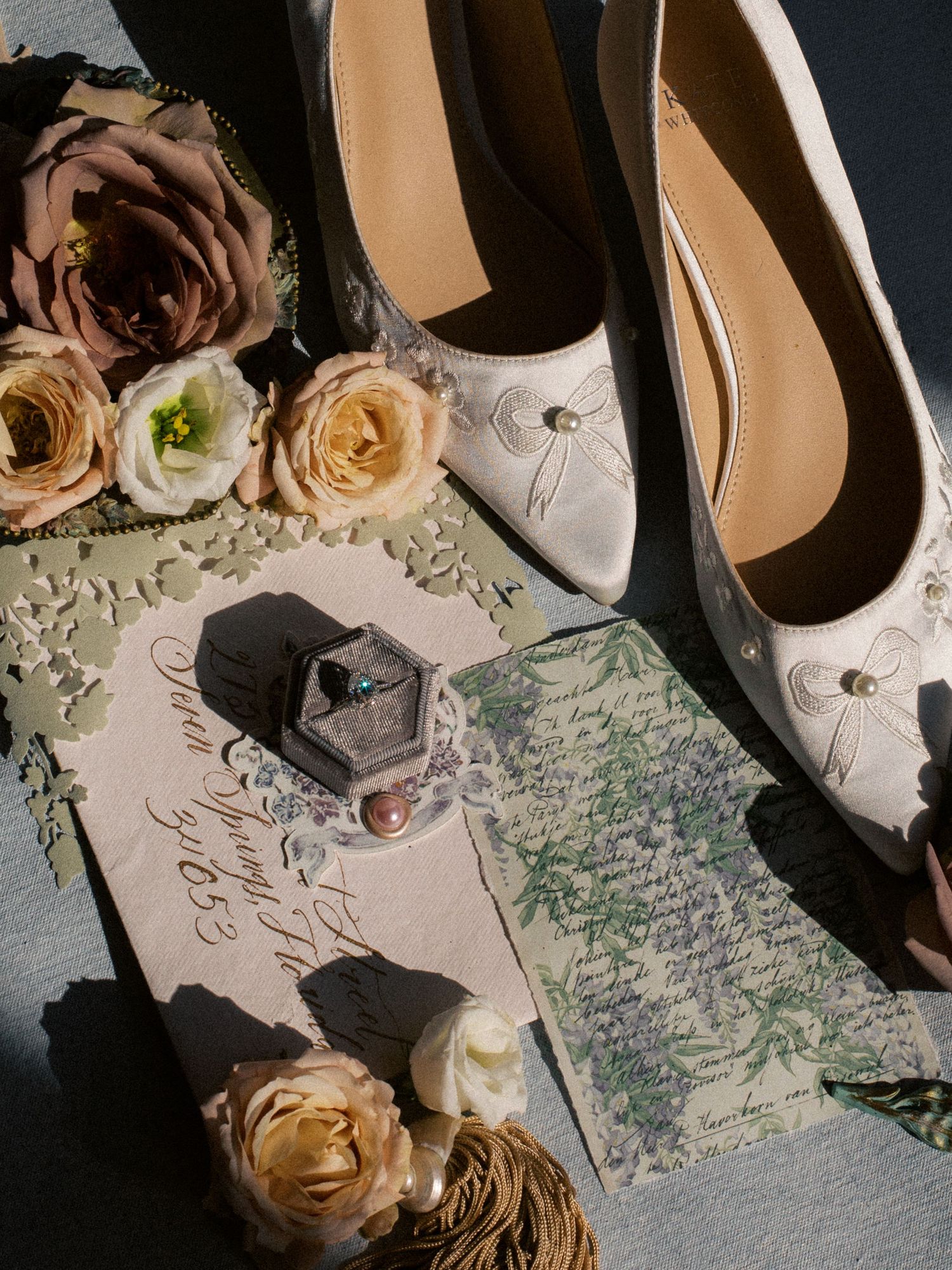 Wedding details including bridal shoes, roses, and handwritten letter in dramatic lighting.