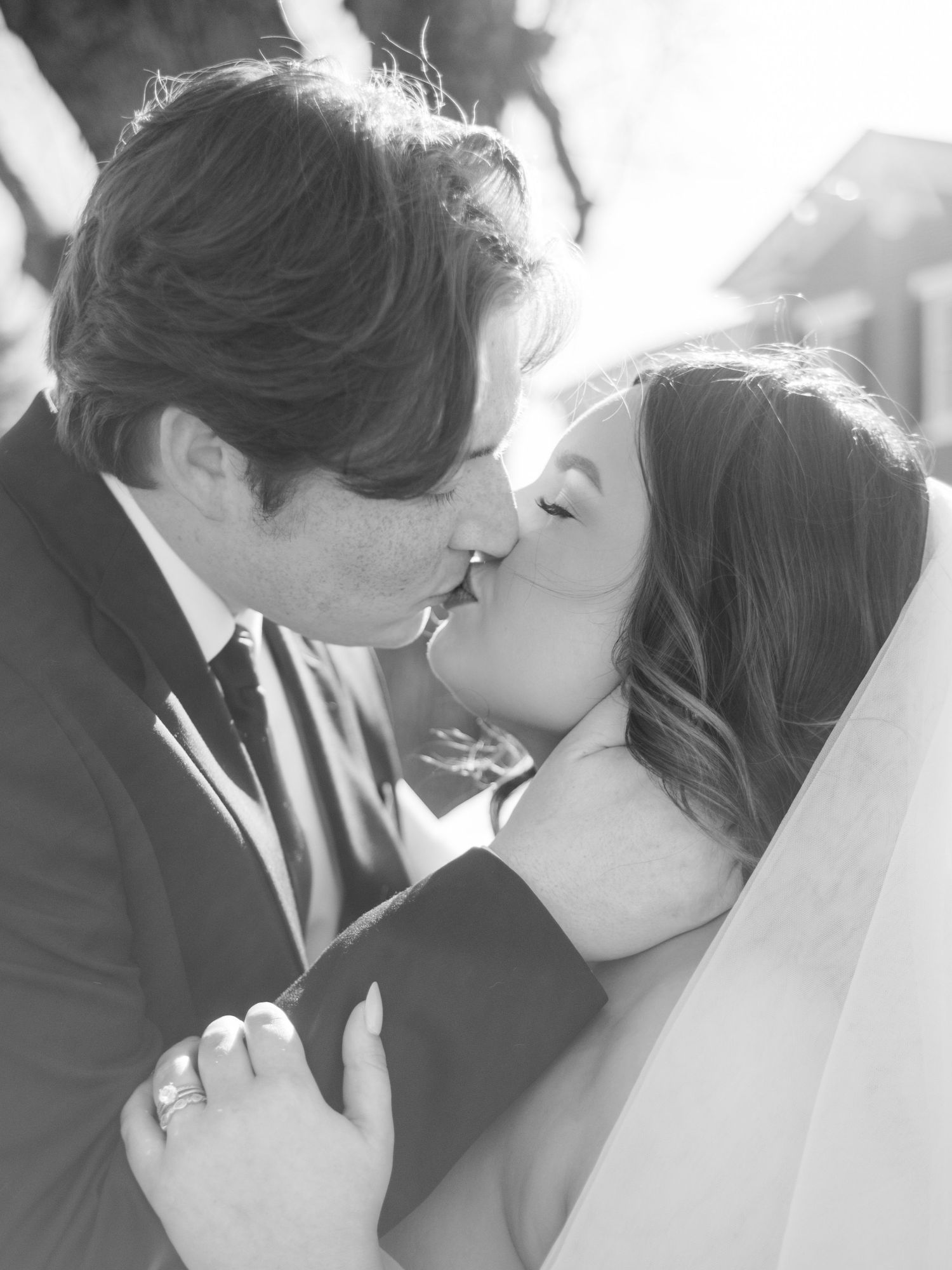 Black and white romantic wedding moment sequence showing a tender kiss.