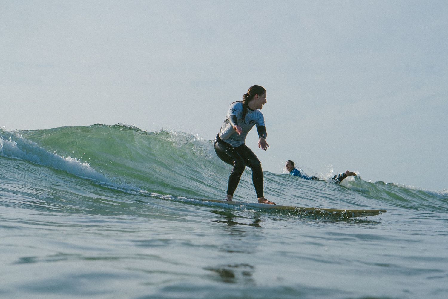 Surfer riding a green wave during daytime ocean session.