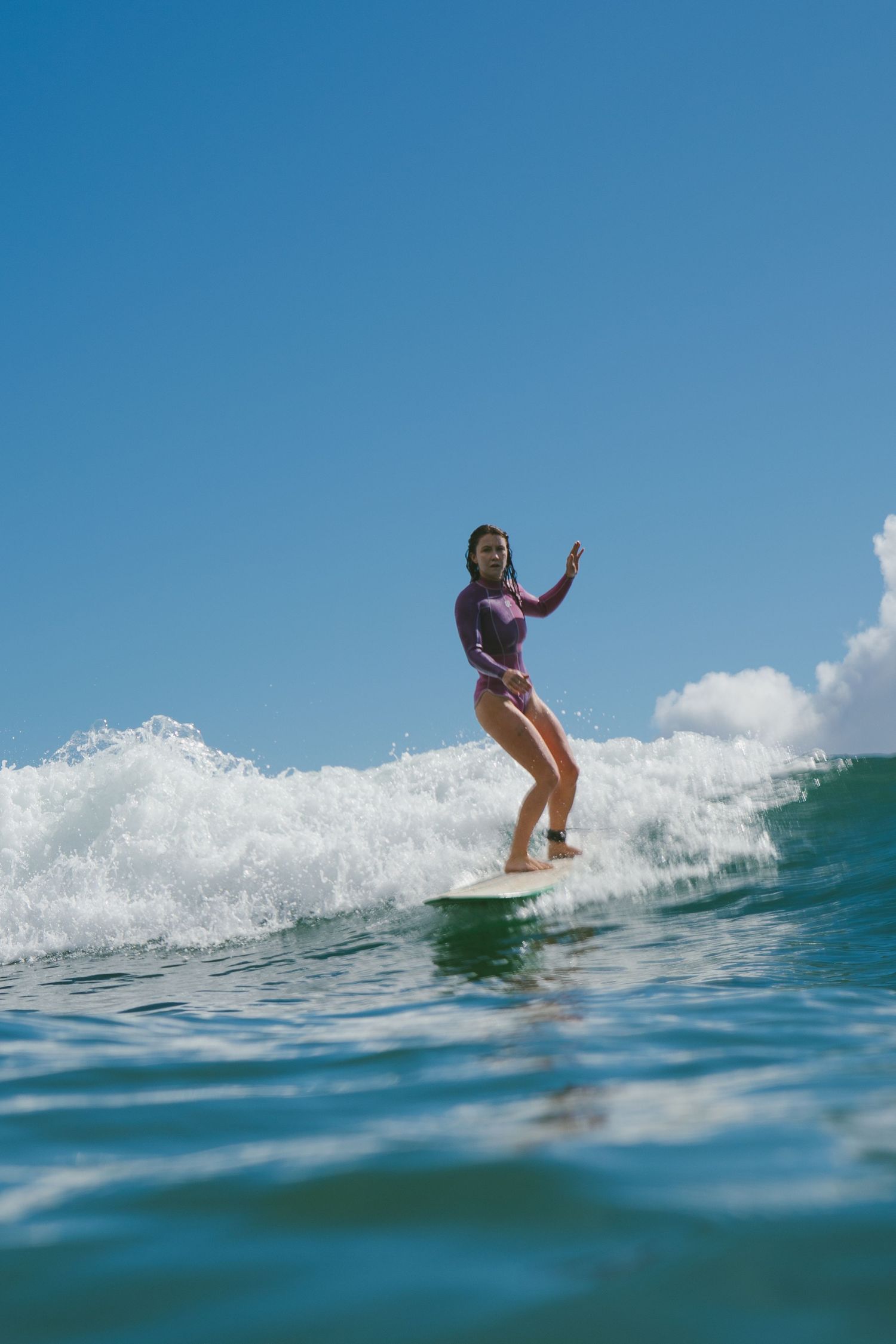 Surfer skillfully rides the crest of a breaking turquoise wave.
