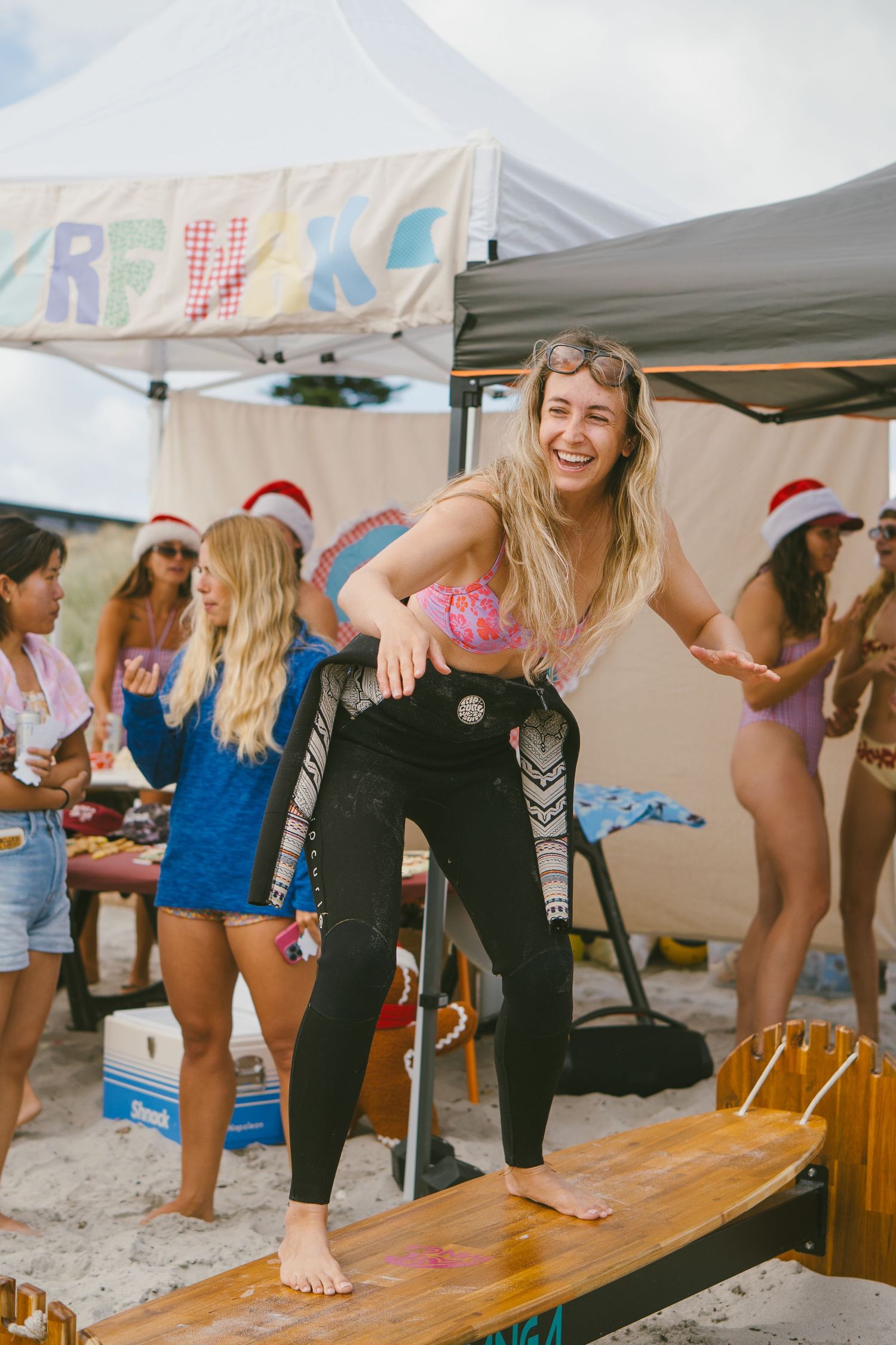 Group having fun and playing games under beach tents during a festive gathering.