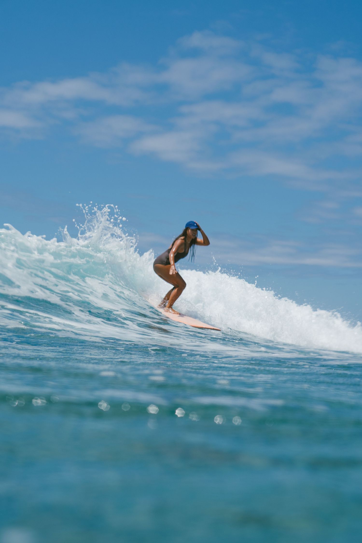 Action shot of surfer catching wave in crystal clear turquoise ocean waters.