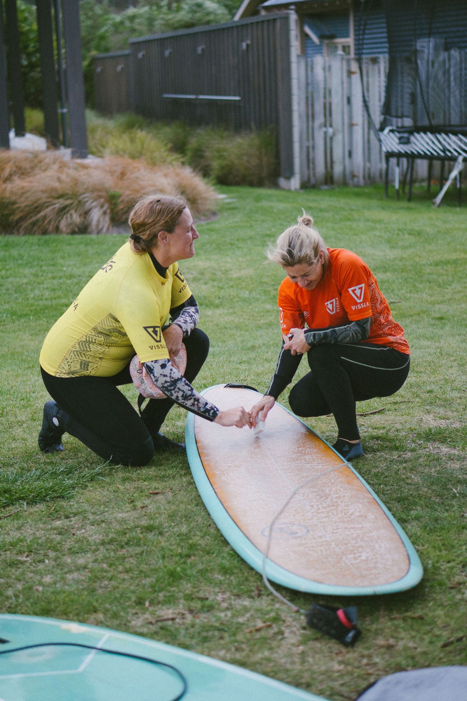 Surfers practicing proper surfing techniques and positions on boards on grass.