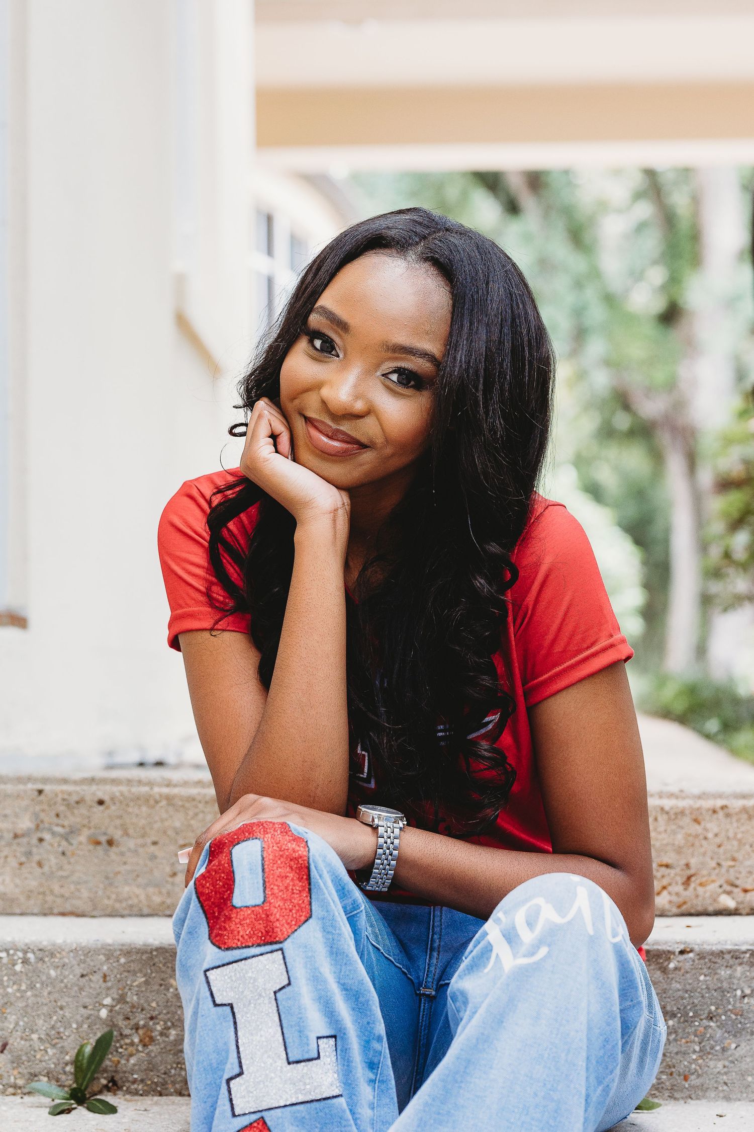 Casual portraits featuring red top and light denim in an architectural setting.