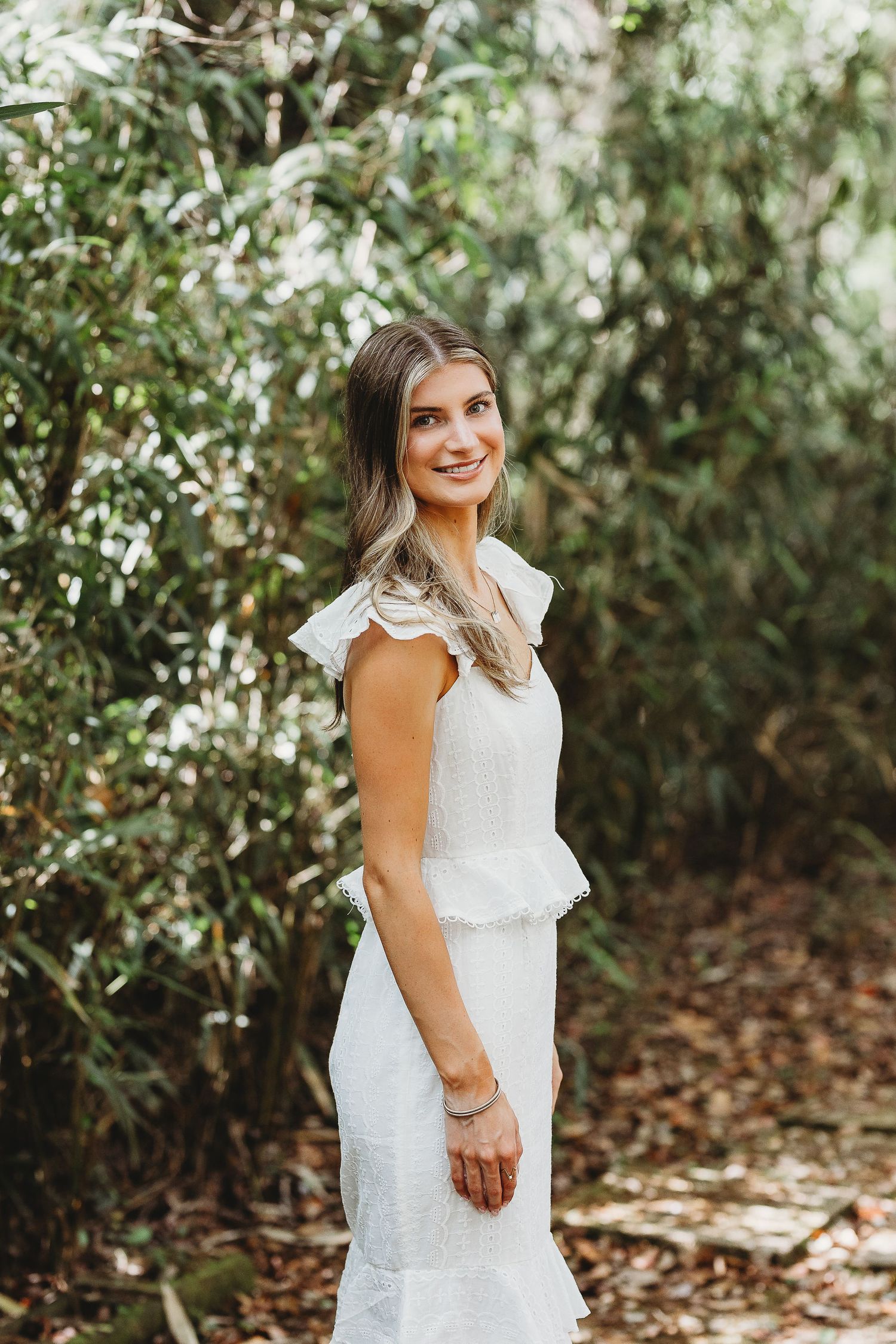 Portrait series in a wooded setting with someone wearing a white lace dress among green foliage.