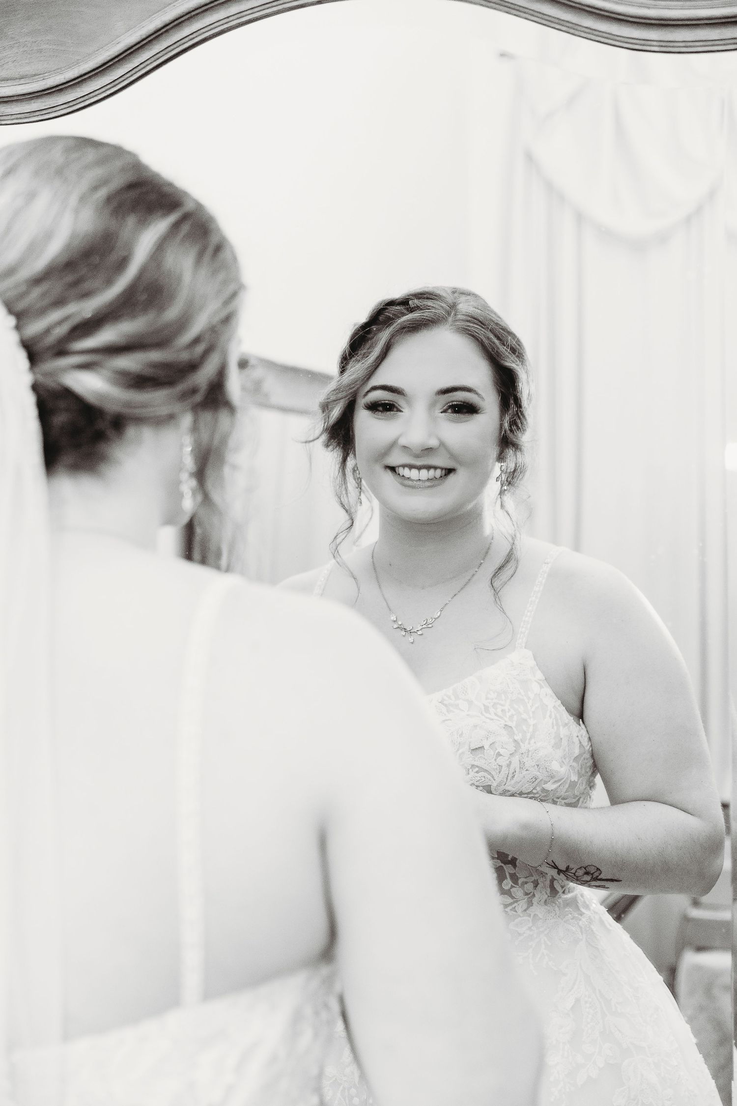 Wedding preparations captured in black and white through an elegant mirror reflection.
