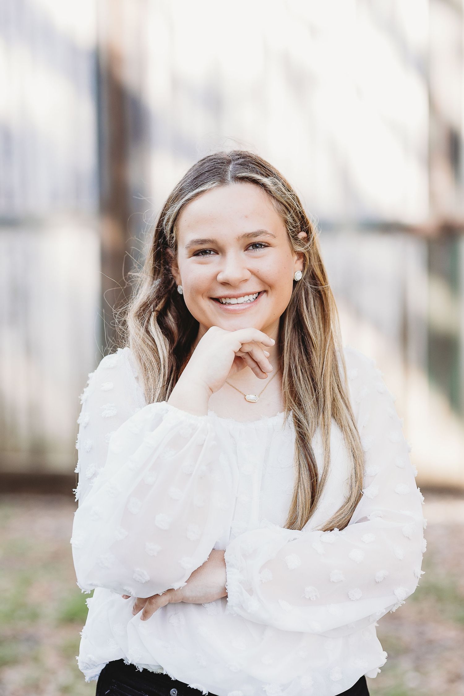 A portrait of someone in a white puffy-sleeved blouse against a blurred background.