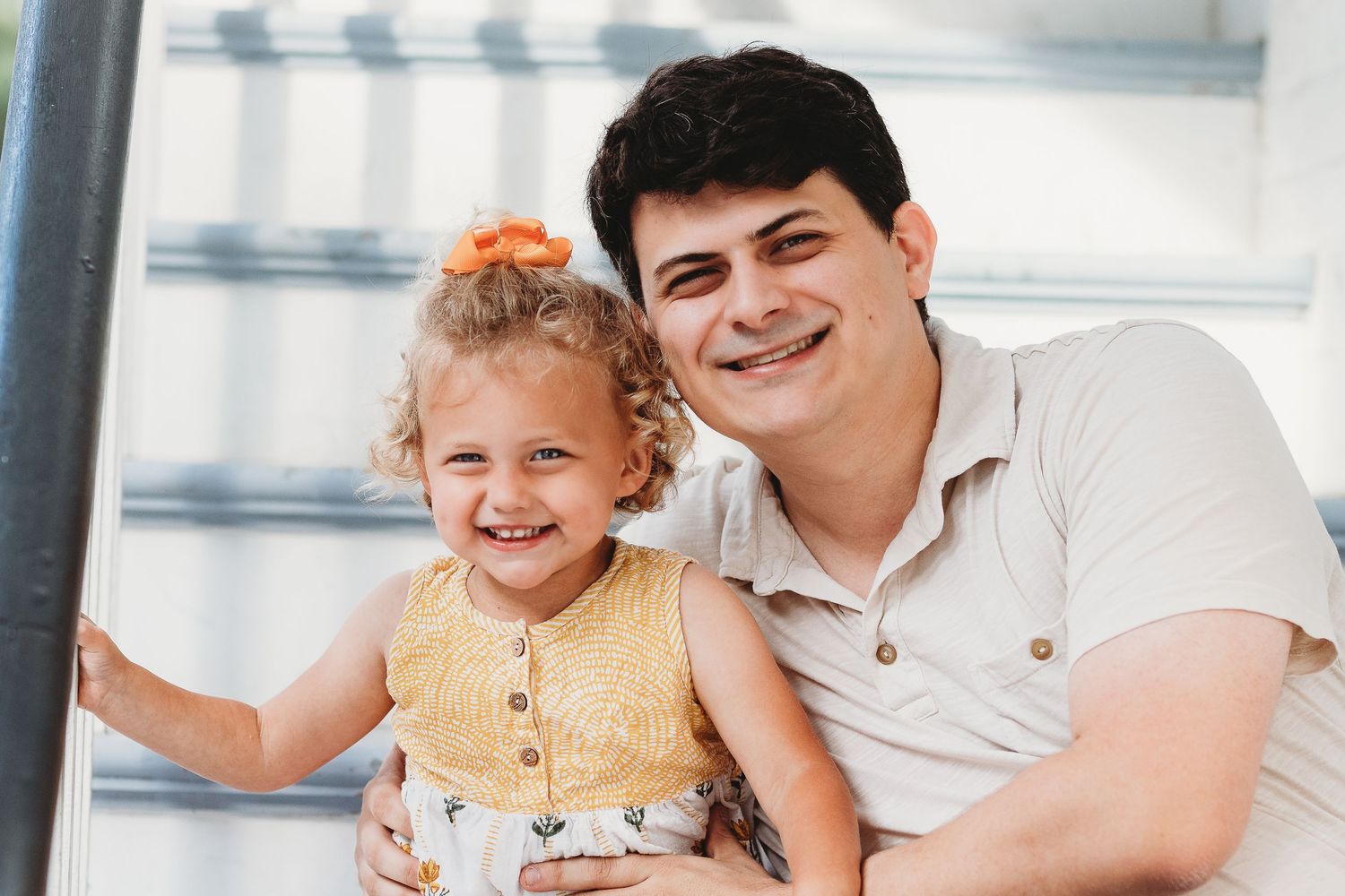 A parent and child share a happy moment on outdoor steps.