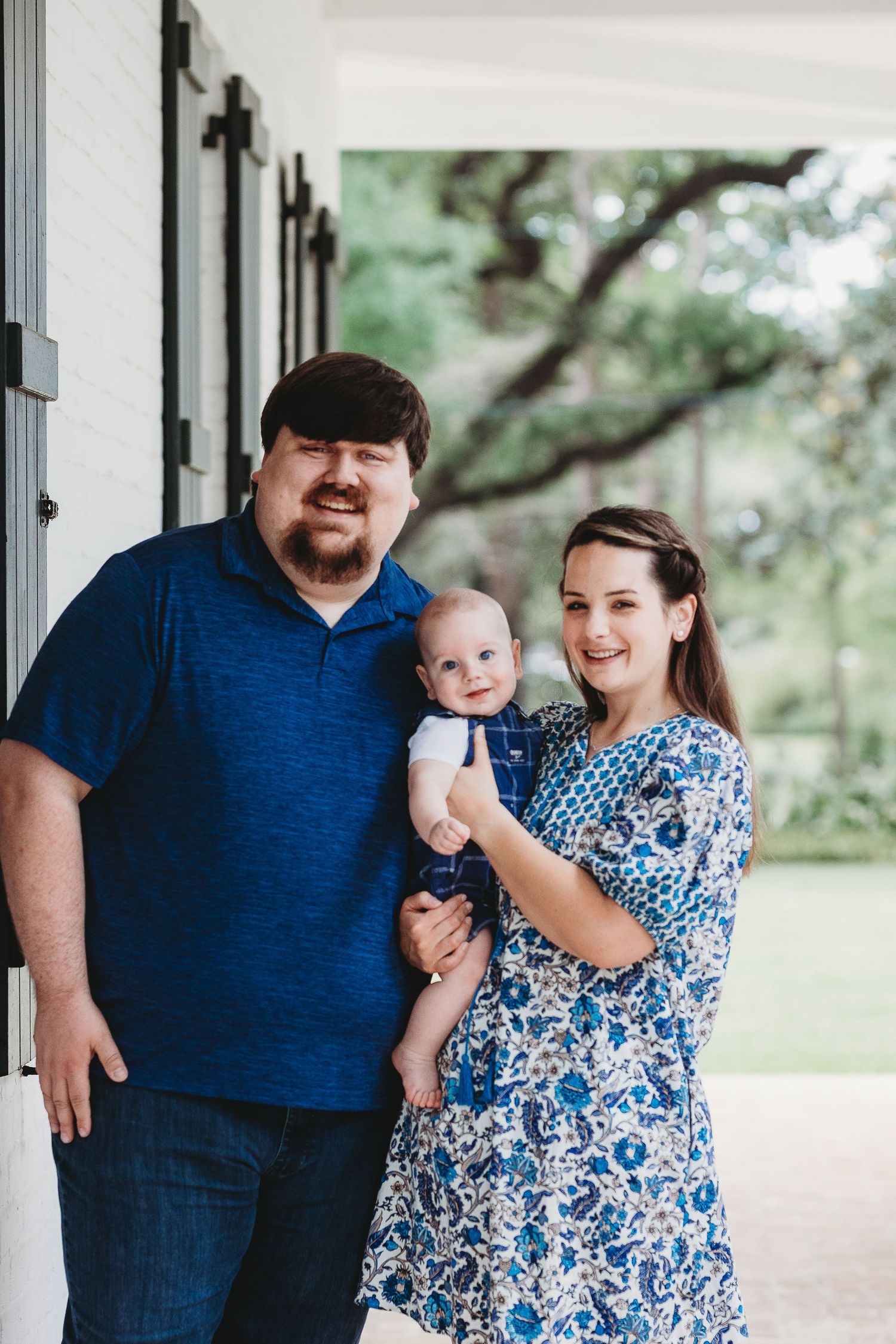 Family portrait under white columns with coordinated blue outfits.