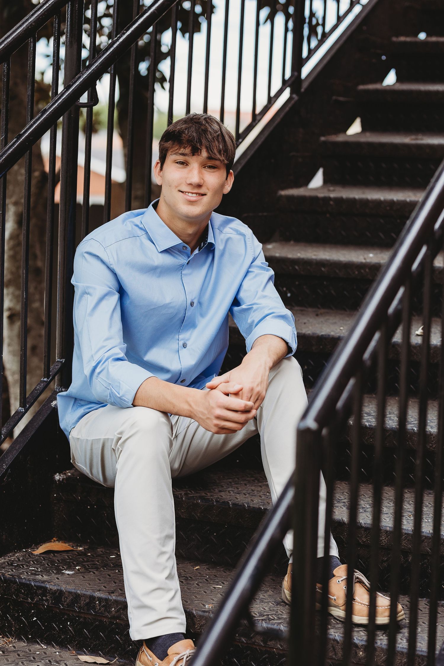 Casual portrait session on outdoor metal staircase with black railings.