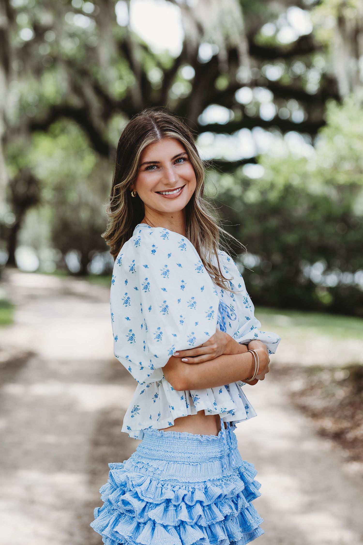 A series of outdoor photos showing someone in a light blue ruffled skirt and floral patterned top against a nature backdrop.