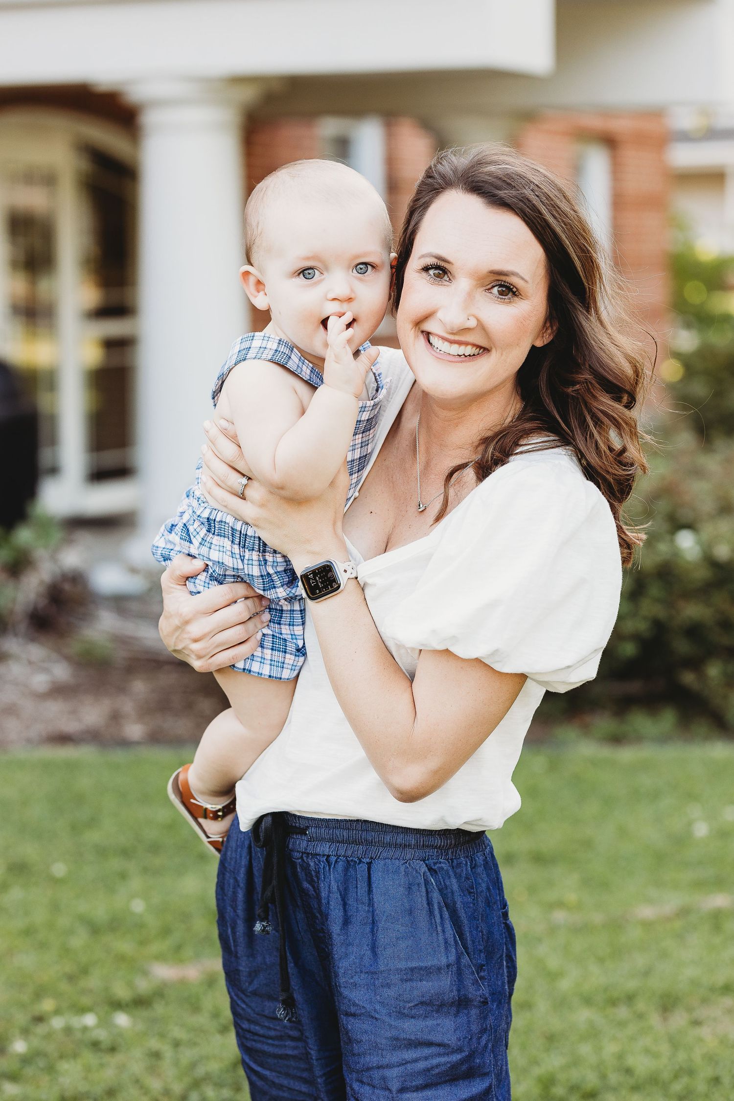 An outdoor portrait featuring casual summer outfits against a brick home backdrop.