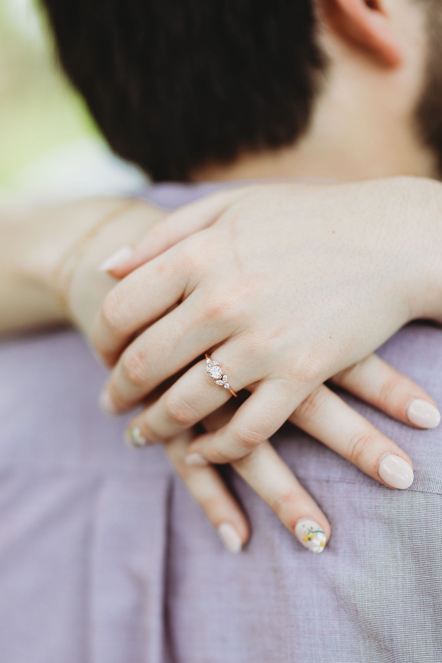 Close-up of engagement ring with sparkly nail polish details.