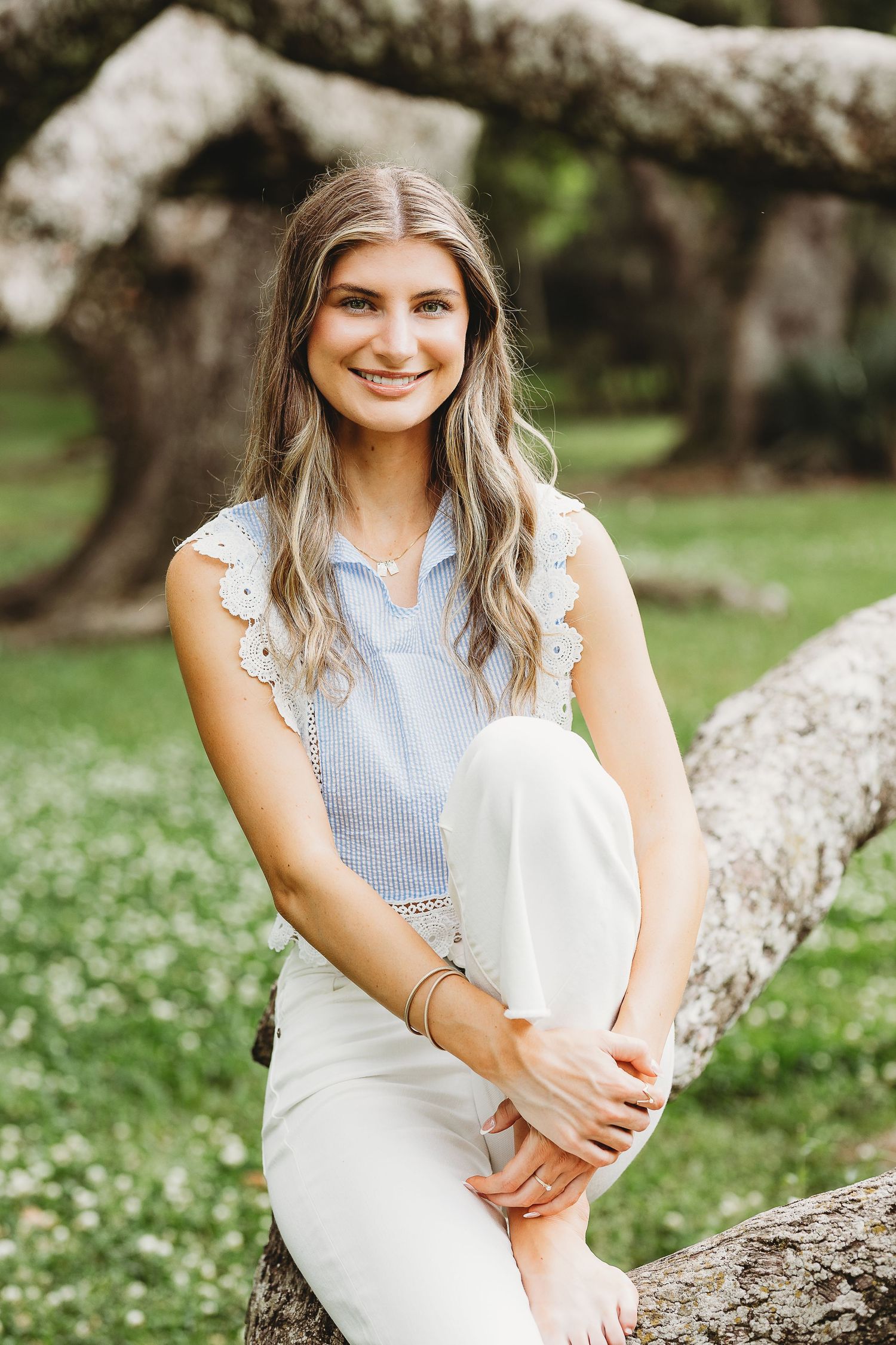 Natural outdoor portraits with someone sitting on rocks wearing light blue and white clothing.
