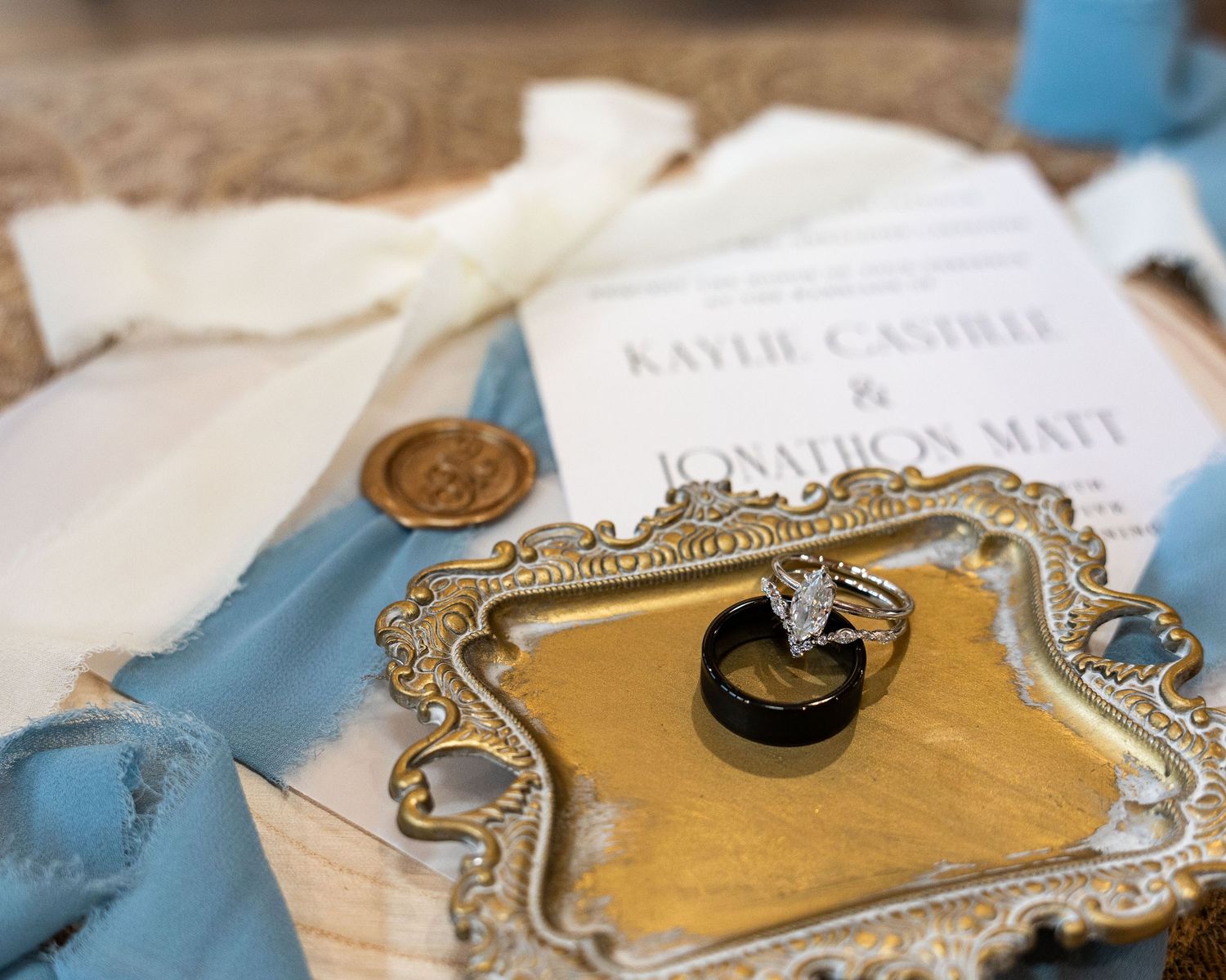 A collection of vintage-style ornate brass key plates arranged on a light blue surface with paper documents.