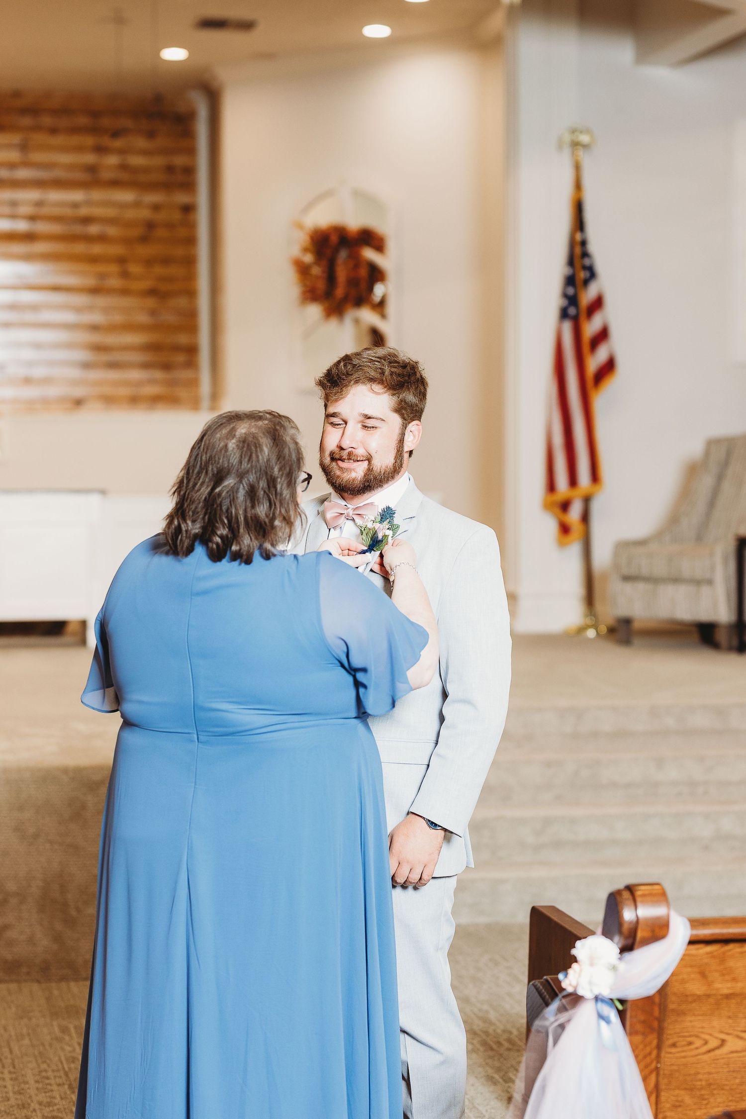 Candid moments captured during a first look reveal in a church sanctuary.